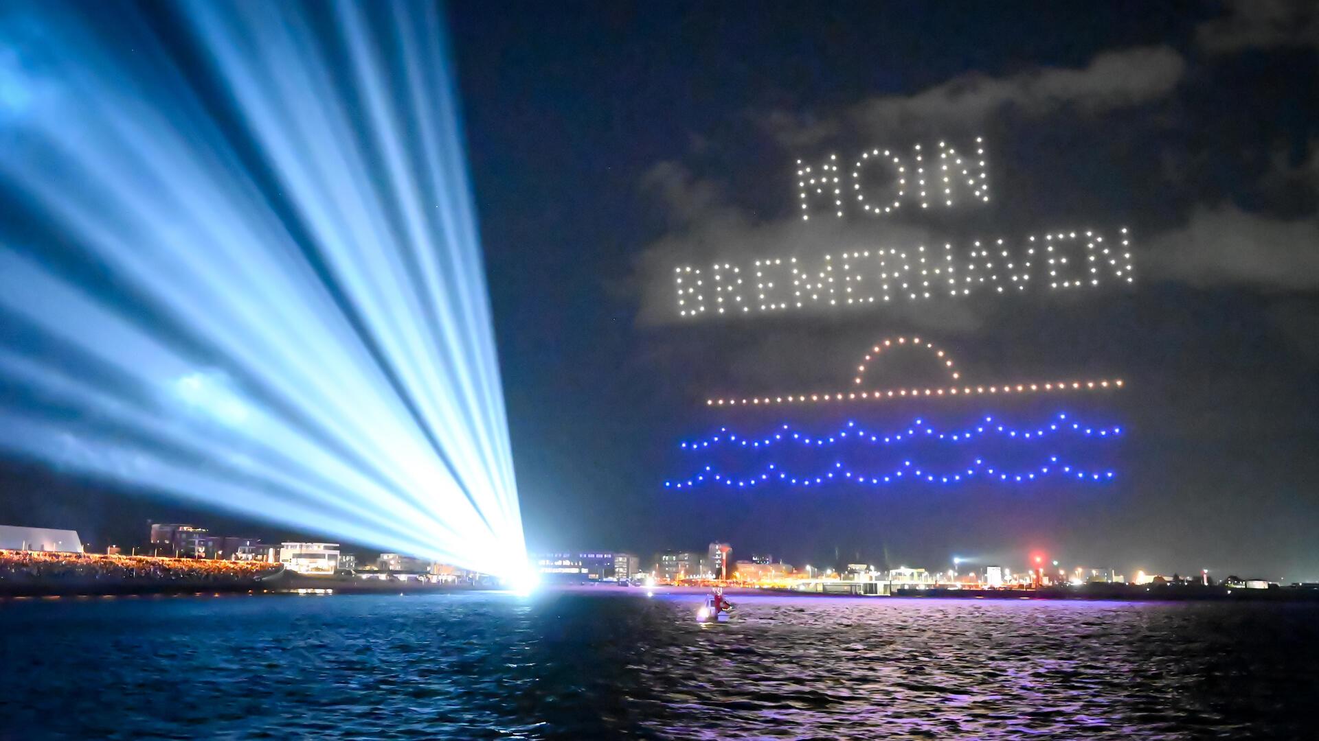 Drohnen schreiben auf der Sail 2025 "Moin Bremerhaven" in den Nachthimmel.