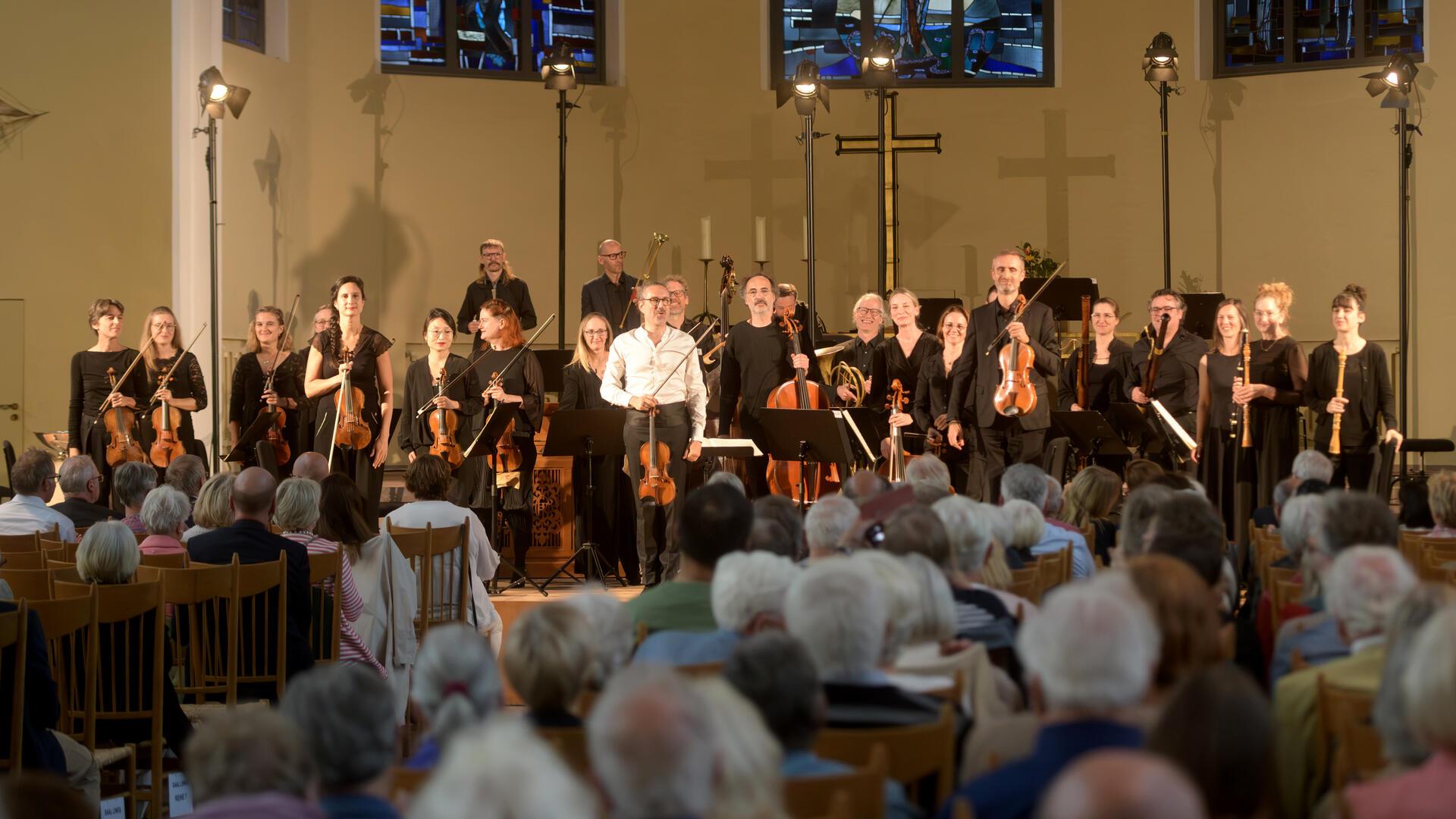 Chor, Dirigent und viele ältere Zuhörer beim Konzert in der Kirche. 