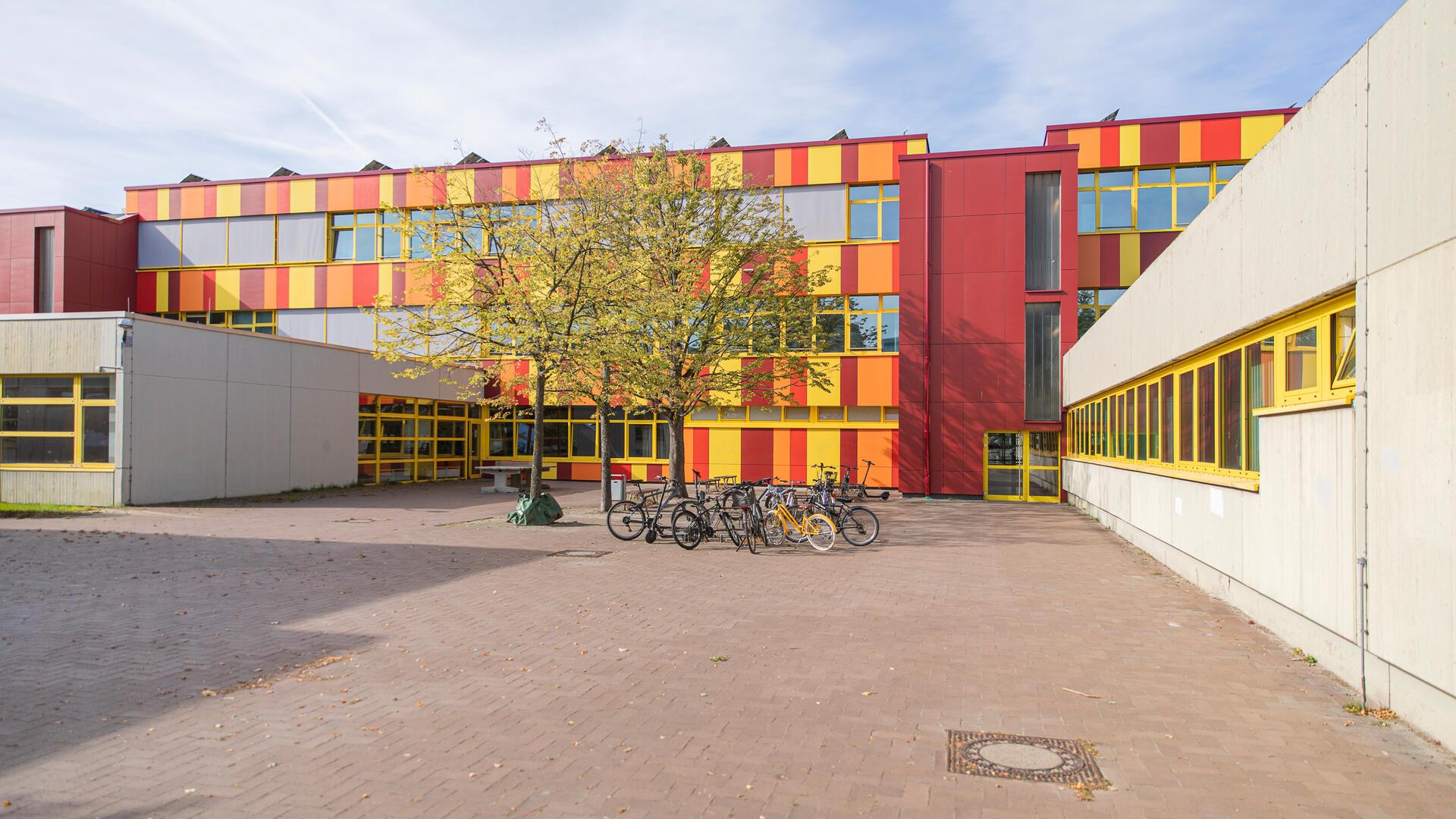 Ein leerer Schulhof, in der Mitte stehen Fahrräder.