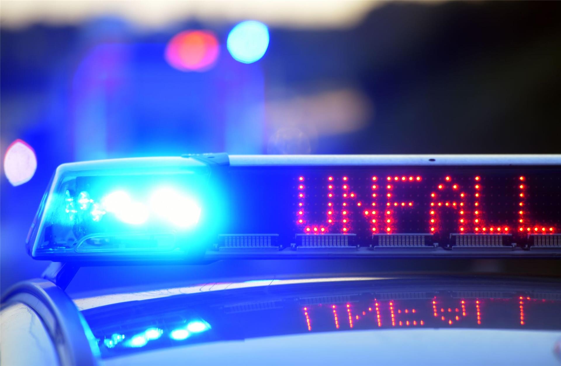 Auf einem Polizeifahrzeug warnt eine Leuchtschrift vor einer Unfallstelle. Nach einem Wildunfall bei Hagen musste ein stark beschädigter Pkw abgeschleppt werden.
