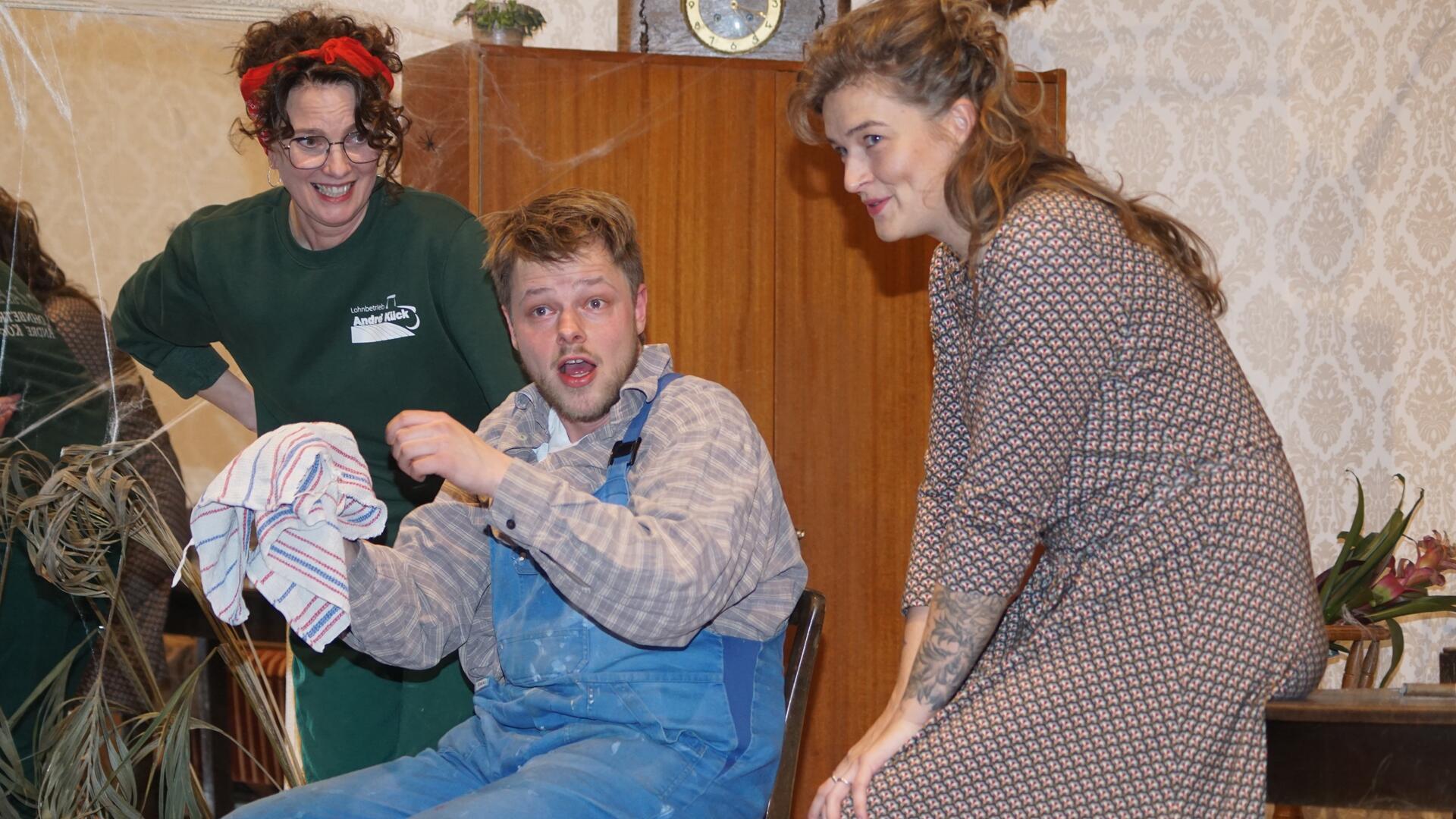 Nachdem Ex-Manager und Neulandwirt Carl Timmermann (gespielt von Janno Poppe) versehentlich einen Bullen gemolken hat, müssen ihn seine Frau Hilde (rechts, gespielt von Franziska Poppe) und Nachbarin Anna Lüthje (Sandra Tomforde-Ernst) erstmal beruhigen. 