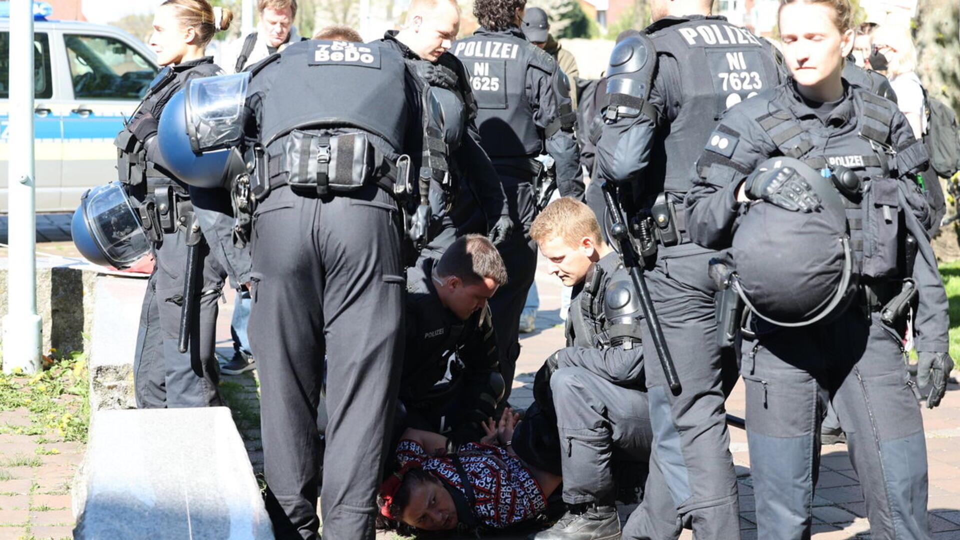 Nachdem sie von einem Beamten geschubst wurde, ging die Frau zu Boden und wehrte sich gegen die Festnahme. 