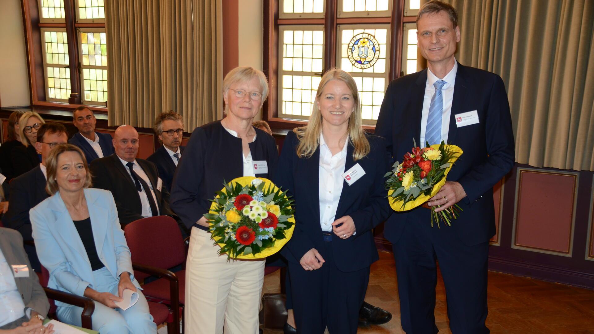Niedersachsens Justizministerin Kathrin Wahlmann (Mitte) mit Ingrid Stelling und ihrem Nachfolger Oliver Sporré im Königsmarcksaal des historischen Stader Rathauses. Links (sitzend) die Präsidentin des Oberlandesgerichts Celle, Stefanie Otte. 