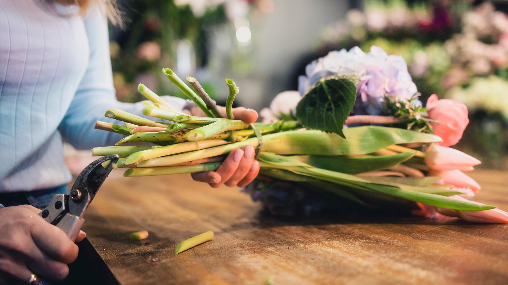 Eine Floristin beim Beschneiden von Blumen.