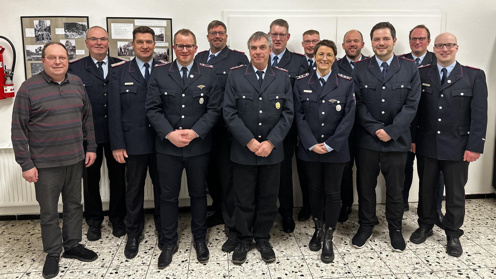 Ortsvorsteher Fridtjof Schröter (von links), Abschnittsleiter Jörg Suske, Stadtbrandmeister Nils Schwarz, Lars Viebrock, der zweite stellvertretende Stadtbrandmeister Holger Burfeindt, Jürgen Dittmer, Ortsbrandmeister Jörg Wempen, Leif Presler, Kristin Witten, Michael Witten, Sören Firlus, Hendrik Schnakenberg und der stellvertretende Ortsbrandmeister Christoph Burfeind.