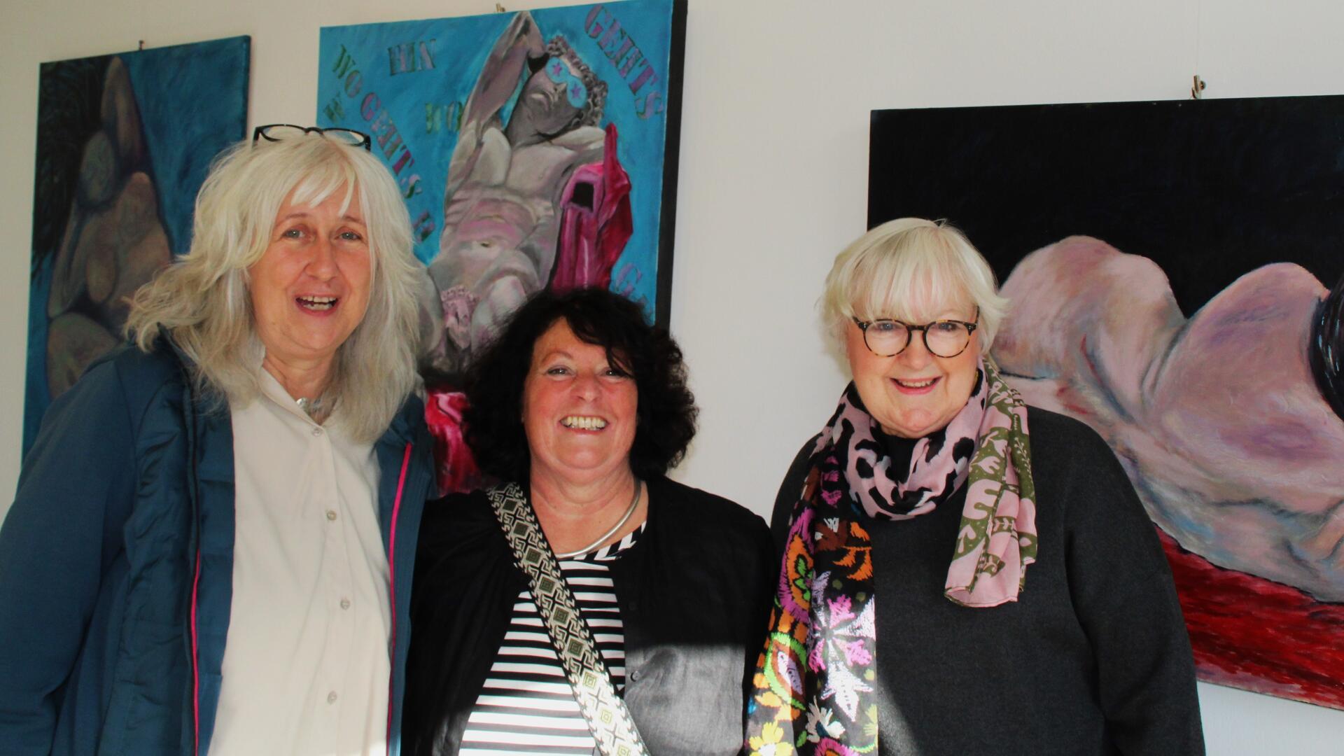 Die Künstlerinnengruppe "Eigenart" mit Petra Hebestreit, Silvia Reinhardt und Anke Steckmann vor ihren großformatigen Werken in der Ausstellung „Menschenleben – Menschen leben – Menschen eben“.