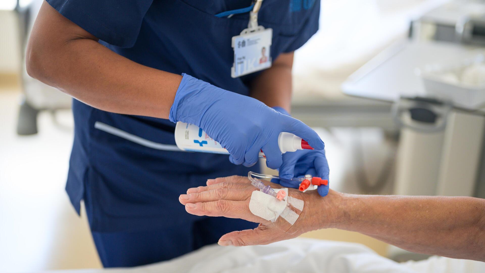 Eine Pflegekraft legt einer Patientin eine Infusion. 