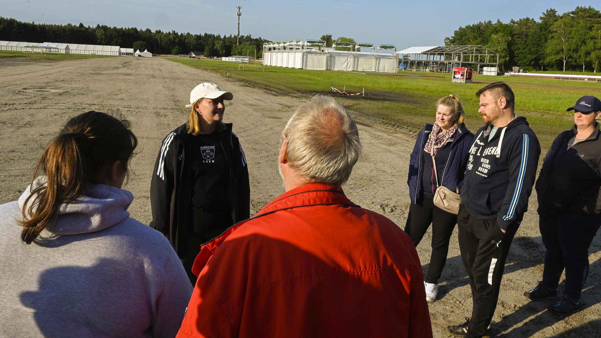 Pirkko Sprengel vom Festival Management erläutert den Besuchern die jüngst gelegte Drainage im Infield.