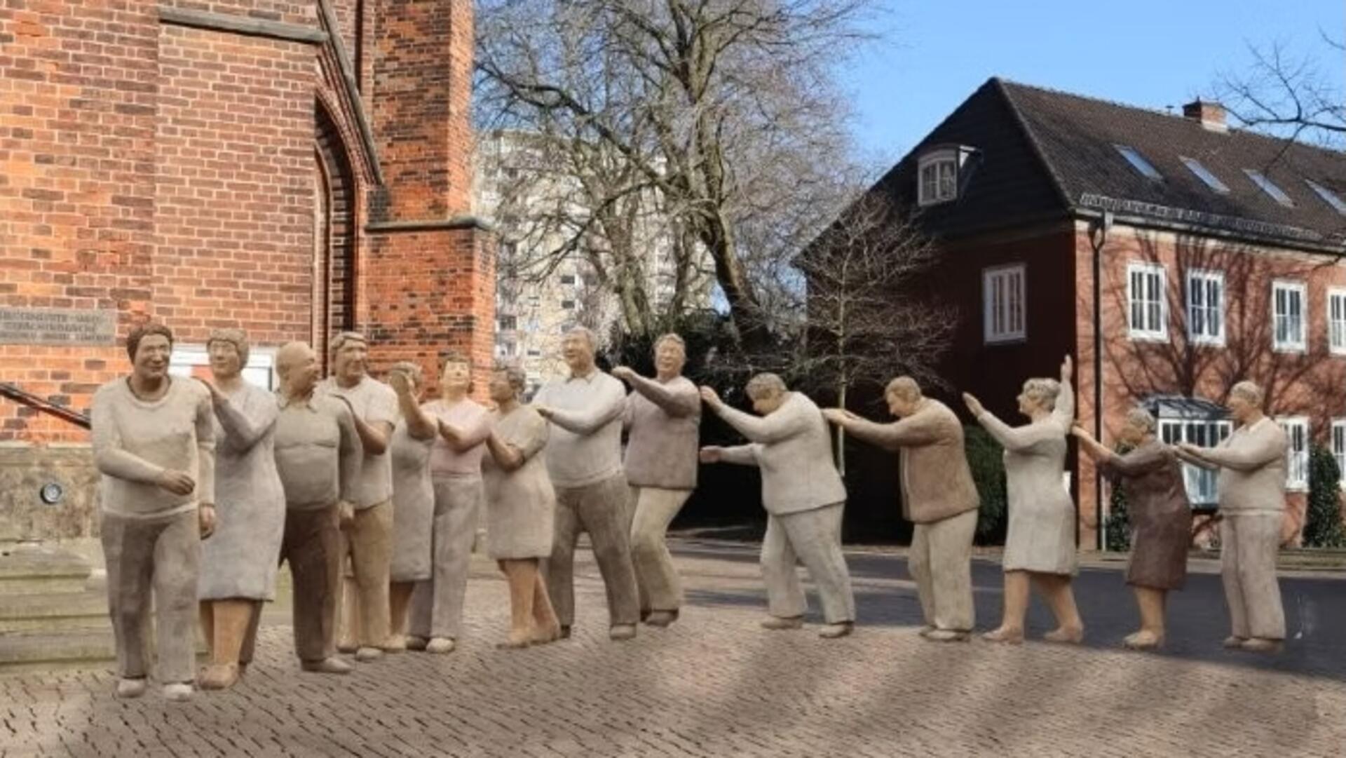 Lebensgroße Figuren in einer Stadt vor einer Kirche, Polonaise.