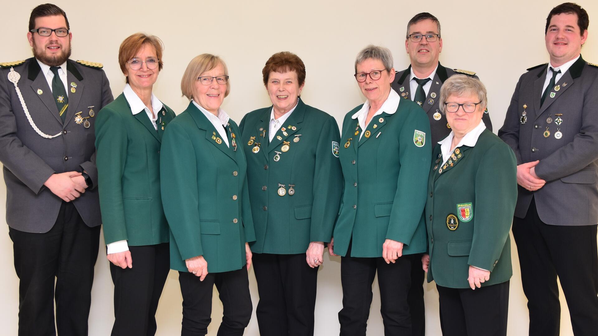 Frauen und Männer in Schützenuniformen stehen nebeneinander in einer Reihe 