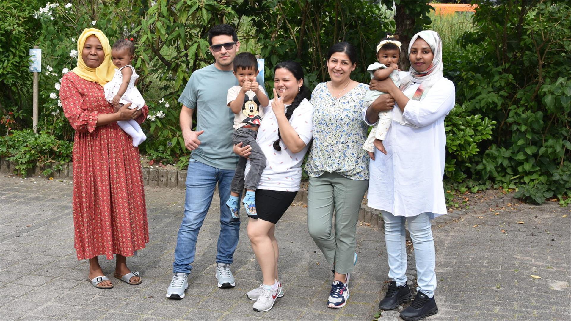 Vier Frauen, ein Mann und drei Kinder posieren für ein Foto.