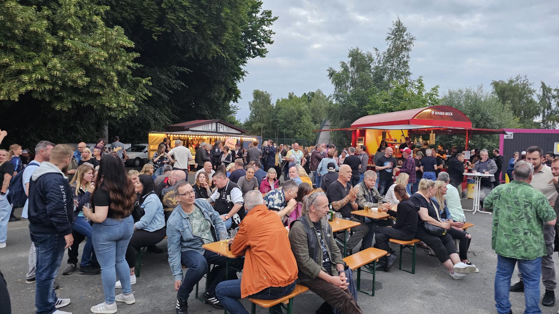 Leute sitzen auf Biergartenbänken