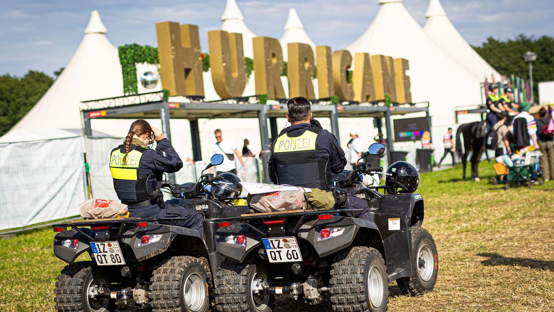 Zwei Personen auf Quads vor weißen Pagodenzelten und dem Schriftzug "Hurricane".
