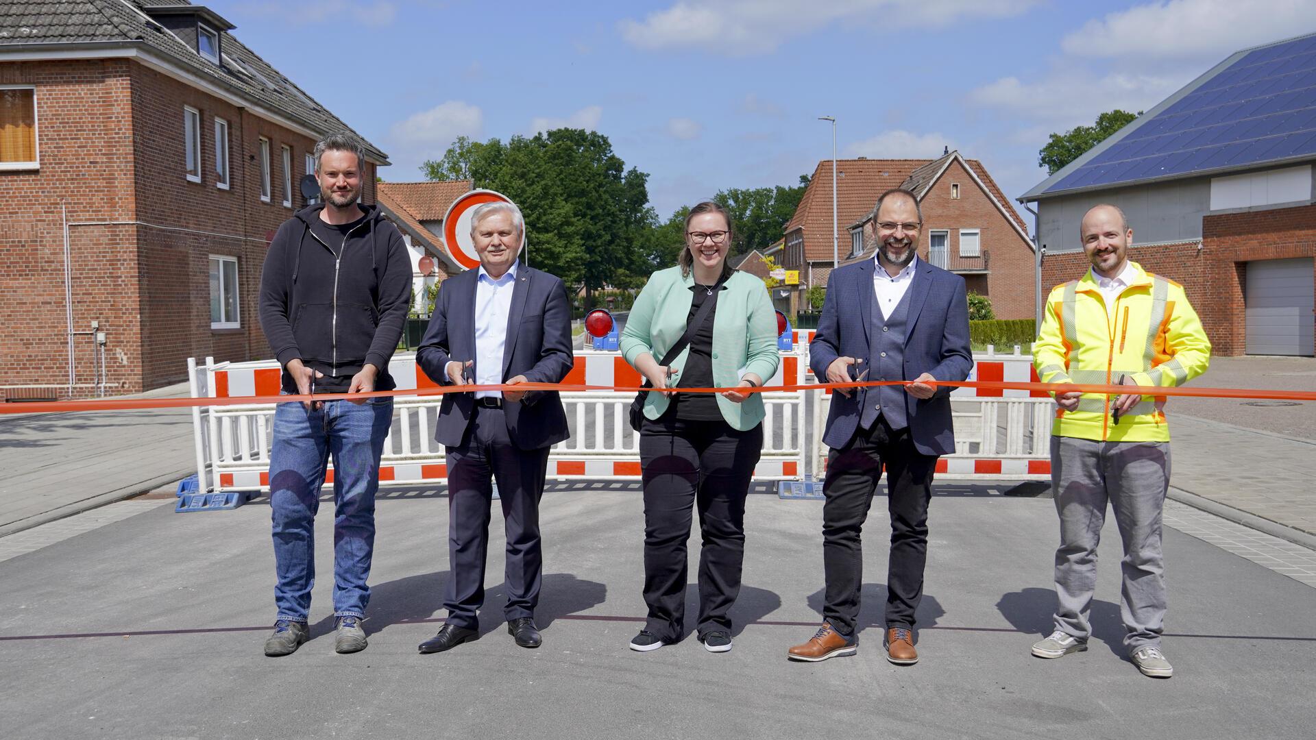 Rund zwei Jahre lang hat die Ortschaft Elm auf diesen Moment gewartet: Am Mittwochnachmittag wurde die komplett sanierte und umgestaltete Elmer Ortsdurchfahrt (Bundesstraße 74) feierlich eingeweiht und für den Durchgangsverkehr freigegeben. Im Rahmen einer Feierstunde durchschnitten Torben Henn (Firma Heino Henn, von links), Elms Ortsbürgermeister Erich Gajdzik, Friederike Wöbse (Geschäftsführerin der Niedersächsischen Landesbehörde für Straßenbau und Verkehr in Stade), Dipl.-Ing. Jens Hinck (Geschäftsführer Matthäi) und Tobias Bersch (Stadt Bremervörde, Fachbereichsleiter Straßen- und Tiefbau) das symbolische rote Band.