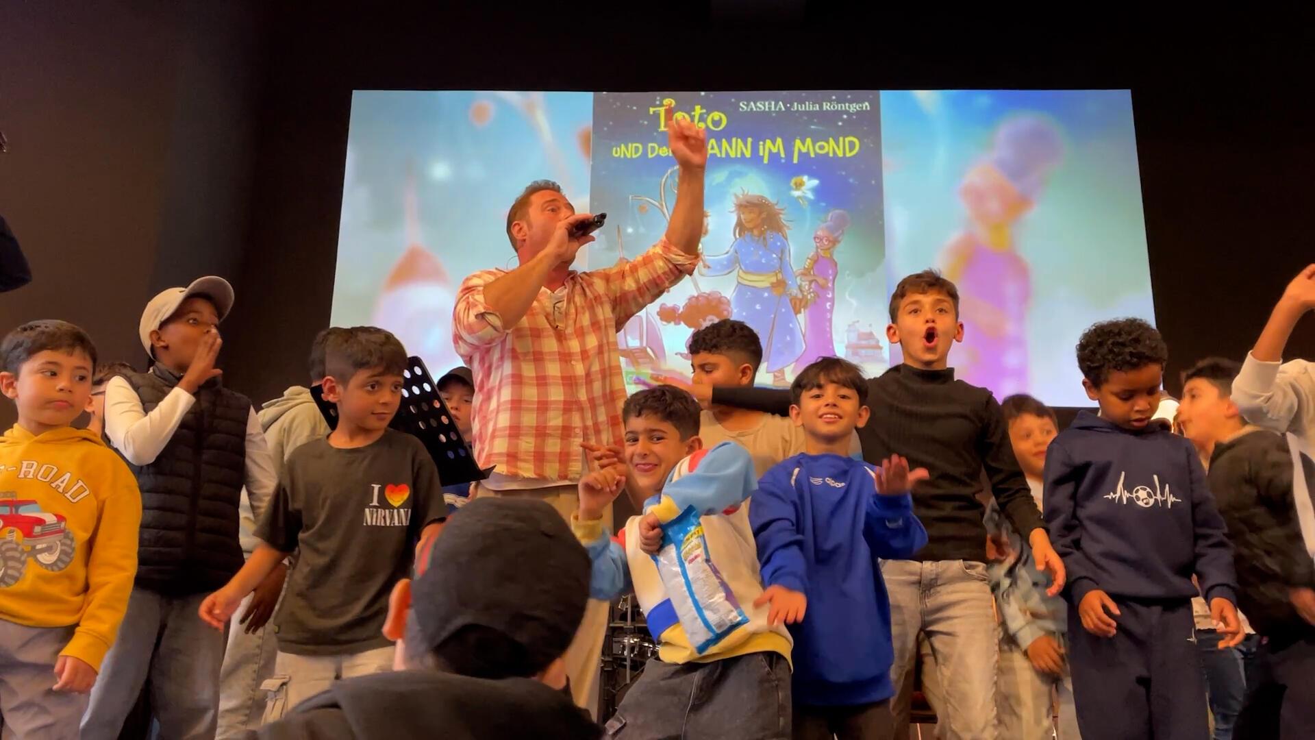 Der Popstar Sasha singt mit Kindern in der Arche Bremerhaven.
