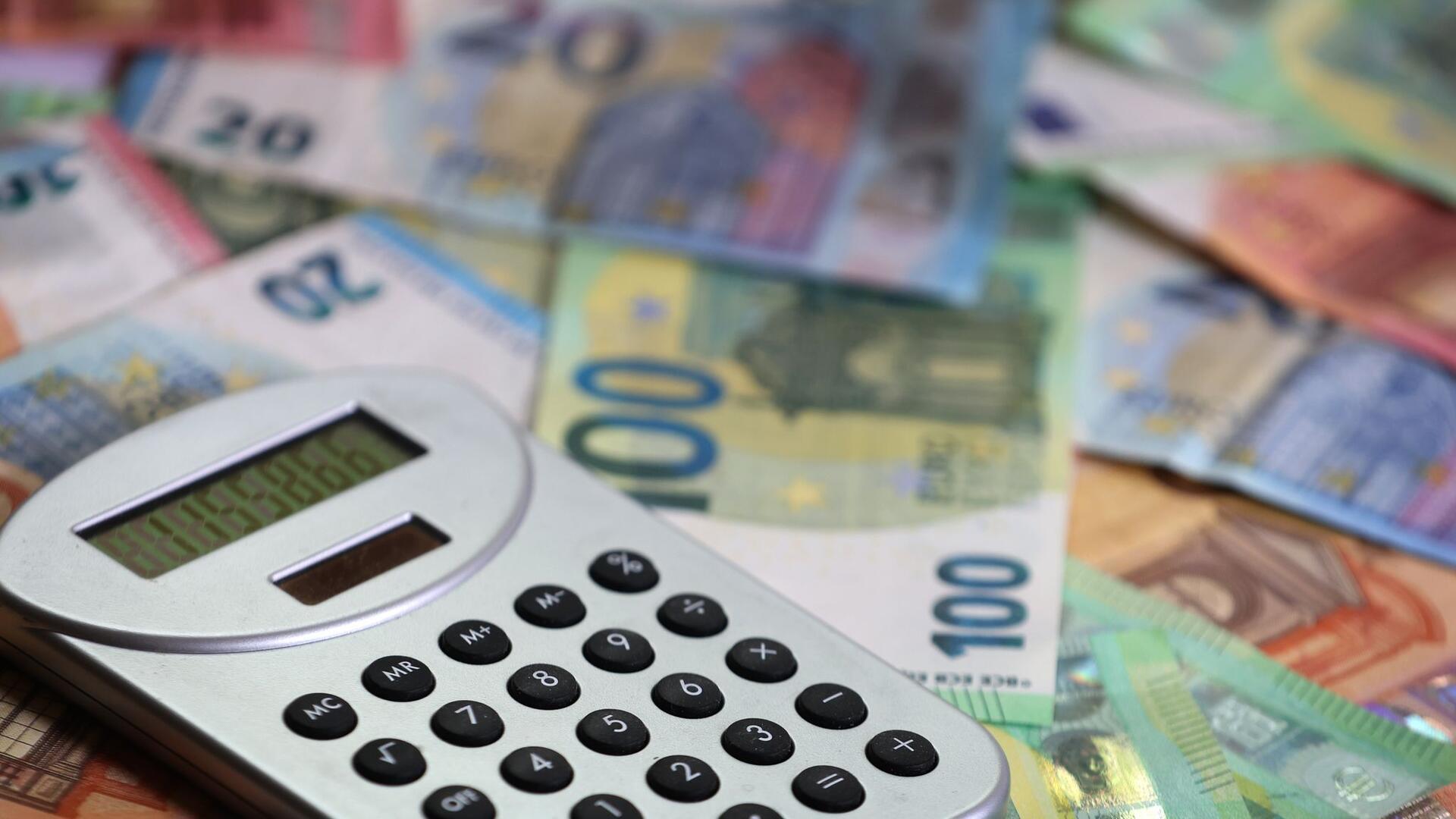 Ein Taschenrechner liegt auf verschiedenen Euro-Banknoten.
