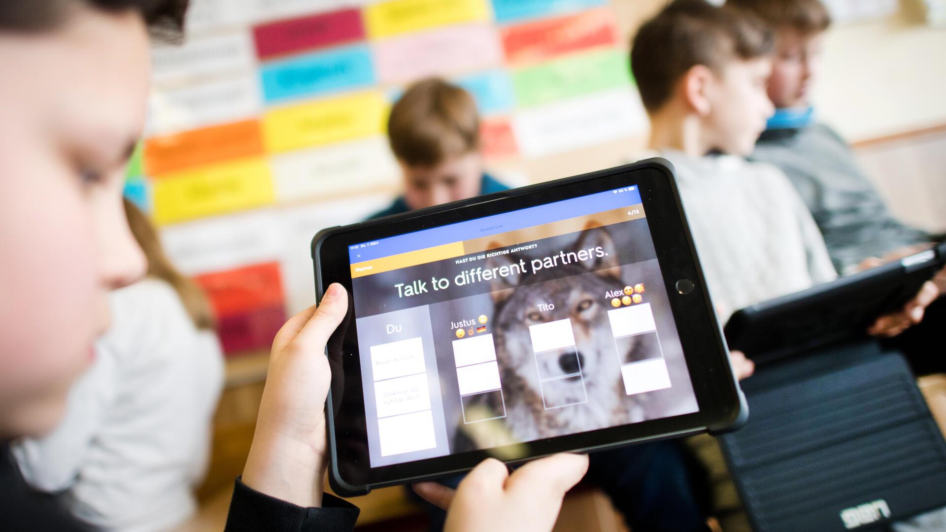 Schüler einer 5. Klasse lernen mit iPads im Englischunterricht.