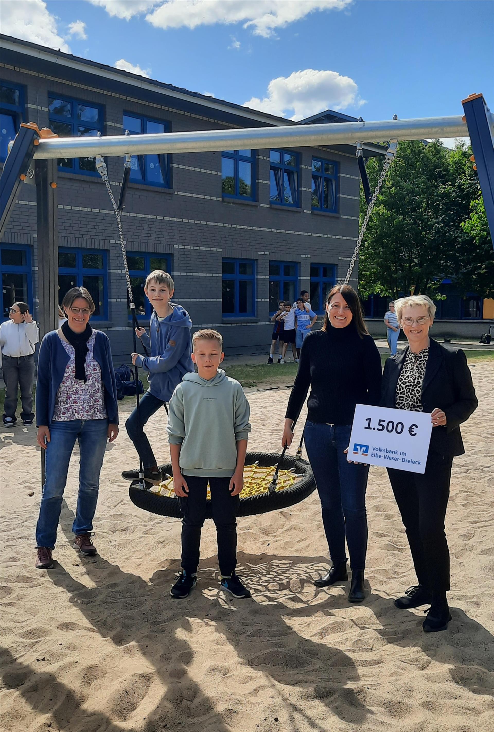 Schulleiterin Sandra Pohl (Zweite von rechts) freut sich mit den Schülern Birk und Lukas über die langersehnte Nestschaukel an der KGS Tarmstedt.
