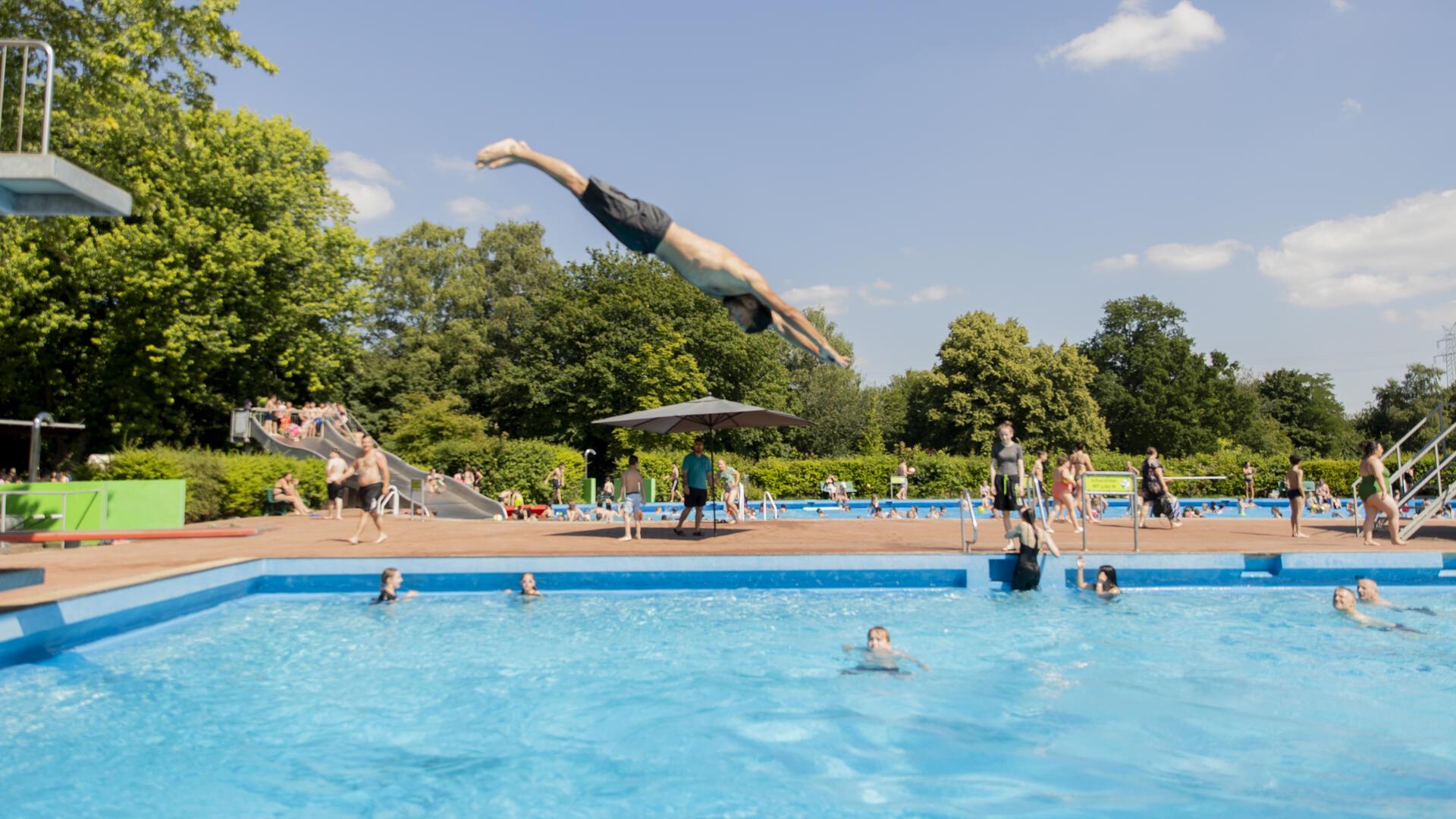 Ein Junge springt ins Wasser. 