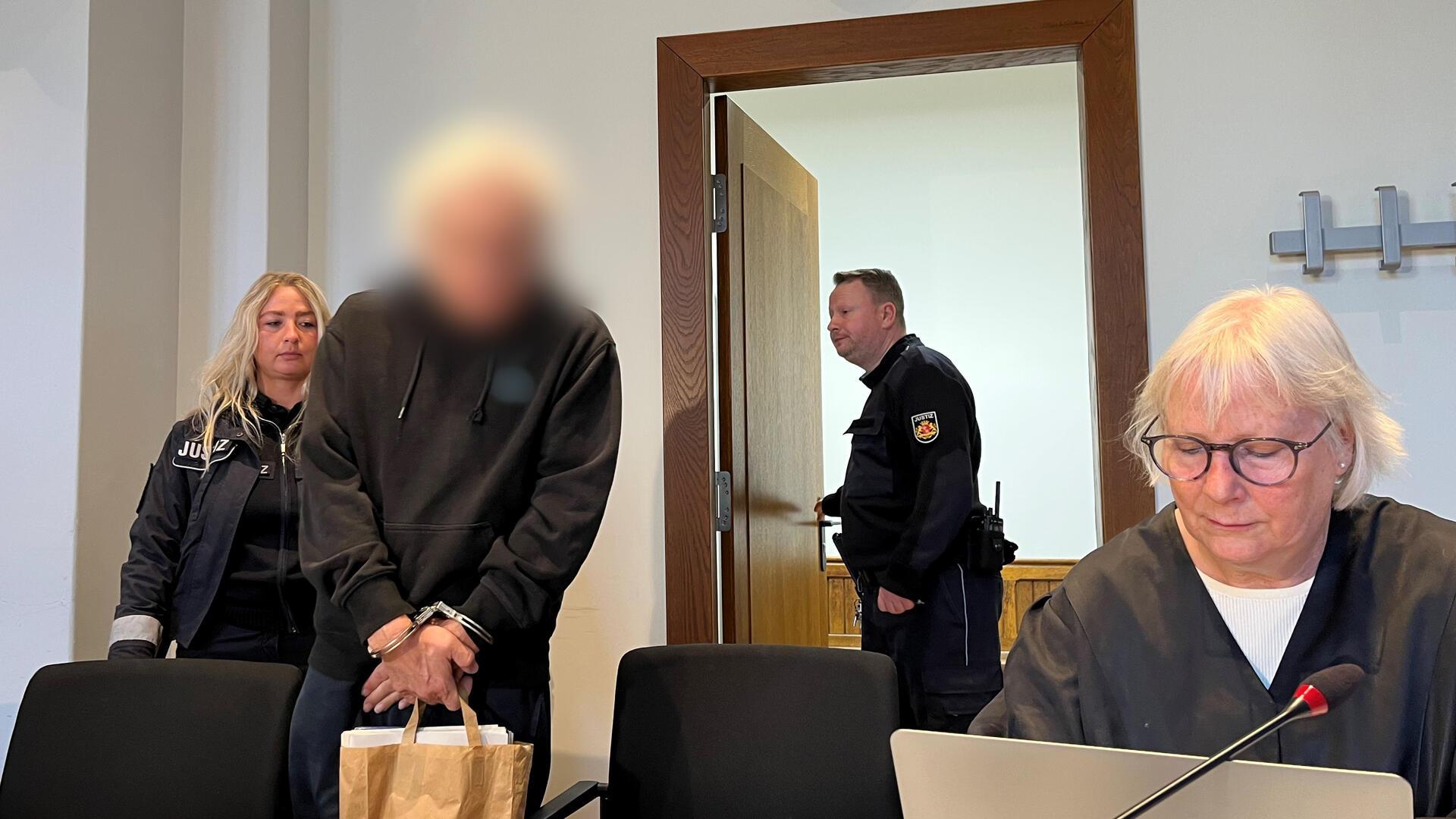 Mann steht in Handschellen im Gerichtssaal.