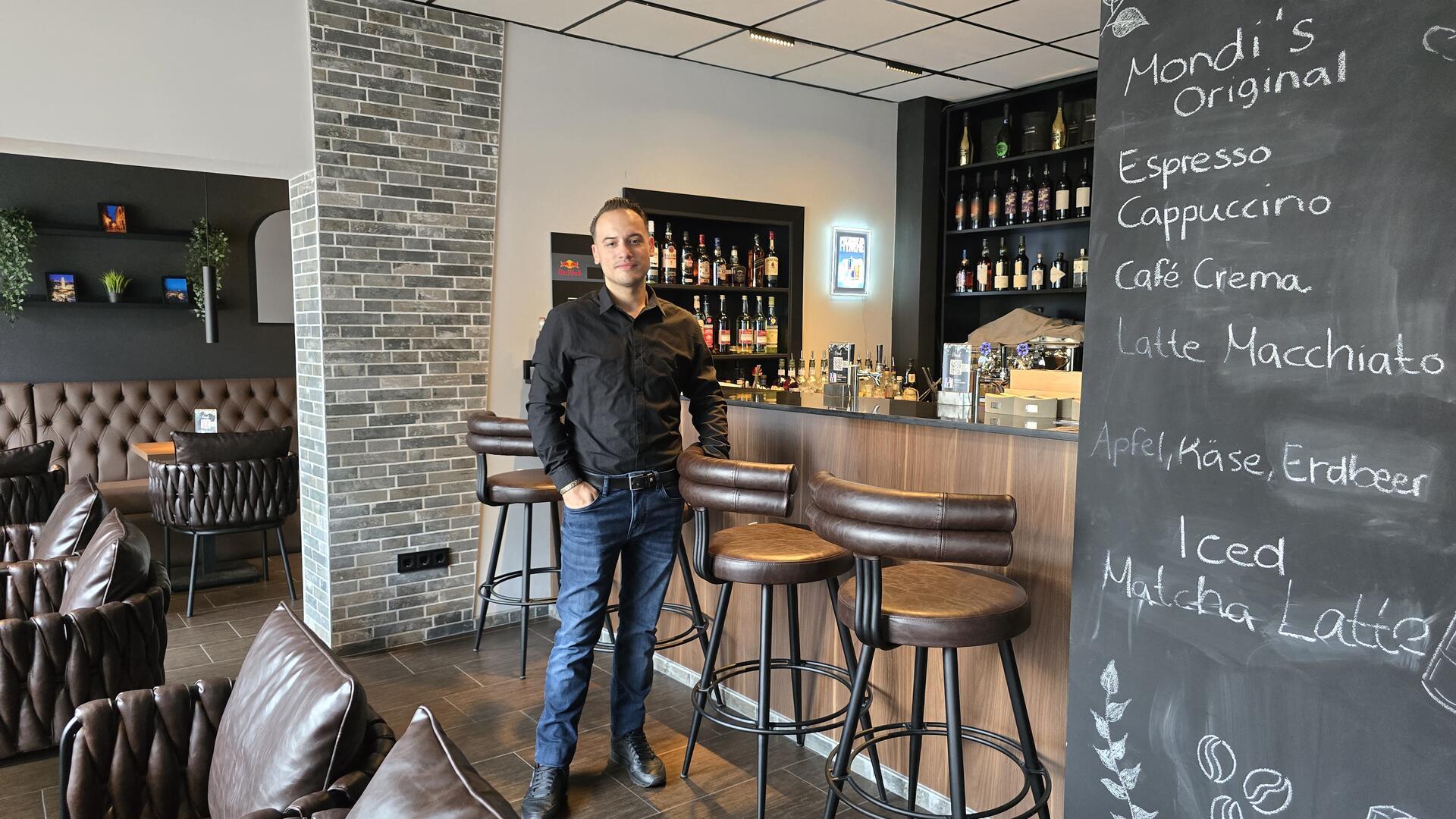 junger Mann in Jeans und Hemd an einer Bar 