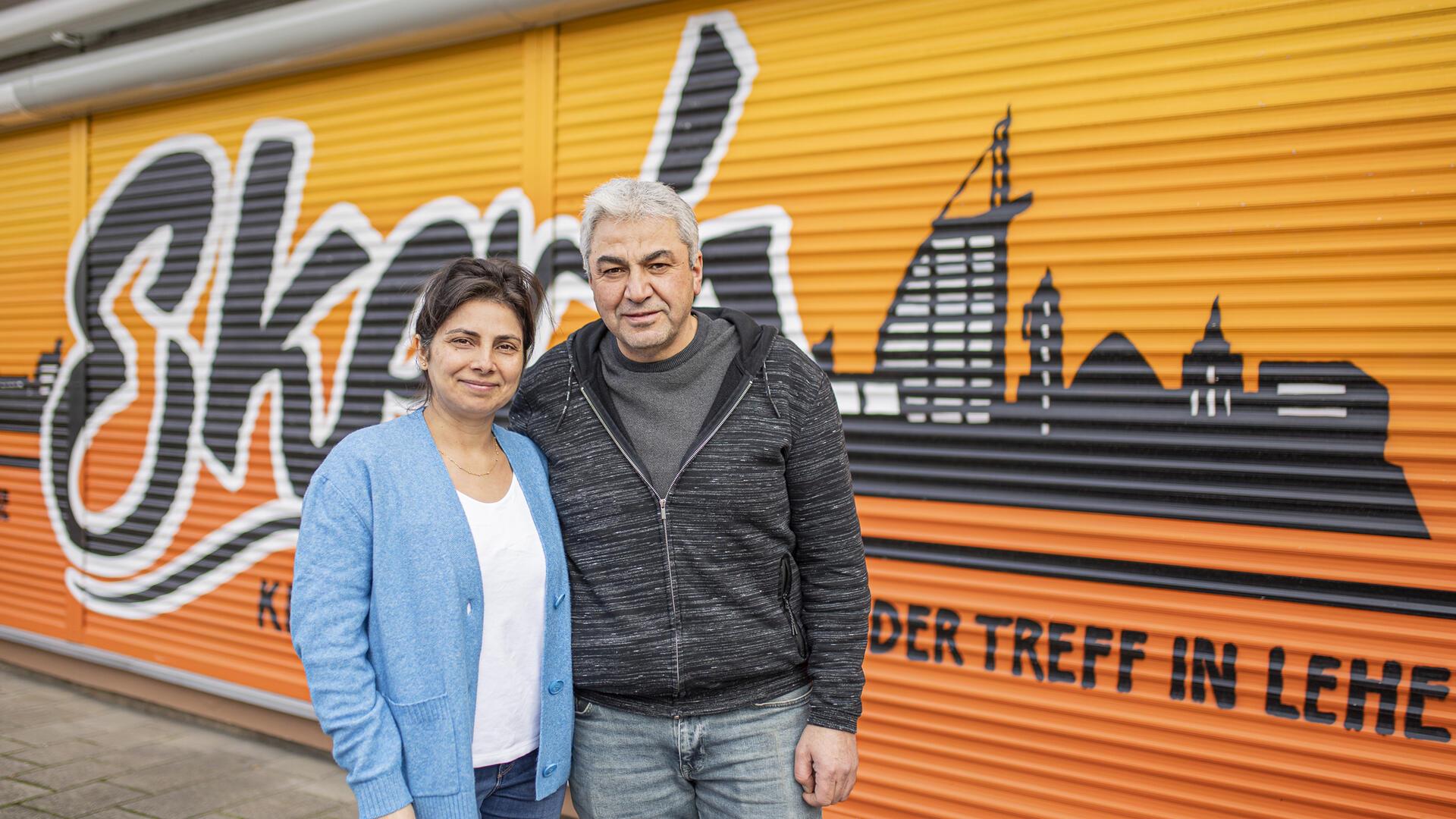 Ein Mann und eine Frau stehen vor einem Kiosk.