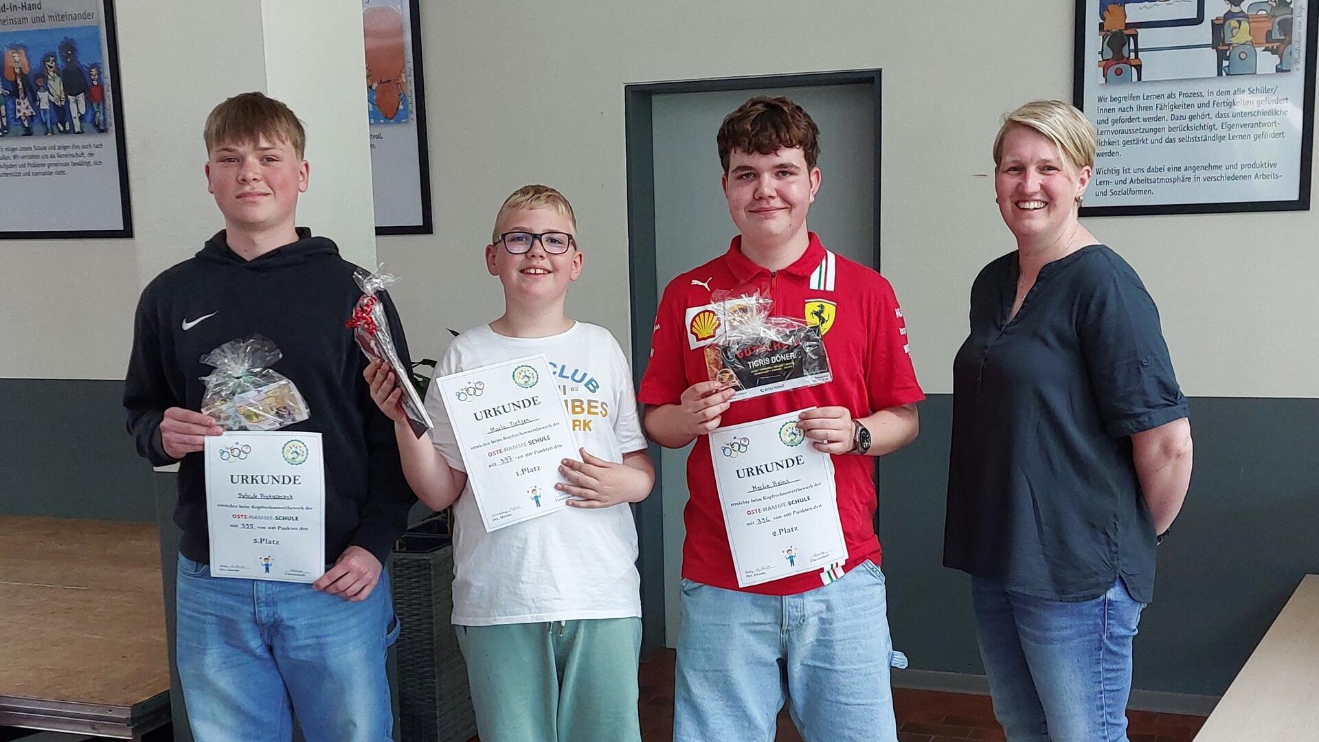 Sie haben unter Zeitdruck ihre mathematischen Fähigkeiten unter Beweis gestellt: Patrick Prykaszczyk (3. Platz, von links), Marlo Tietjen (1. Platz) und Merlin Heins (2.Platz) gingen als Sieger aus dem Kopfrechenwettbwerb der Oste-Hamme-Schule hervor. Lehrerin Jennifer Krause (Fachbereichsleitung Mathematik und Naturwissenschaften) überreichte die Urkunden und Präsente.