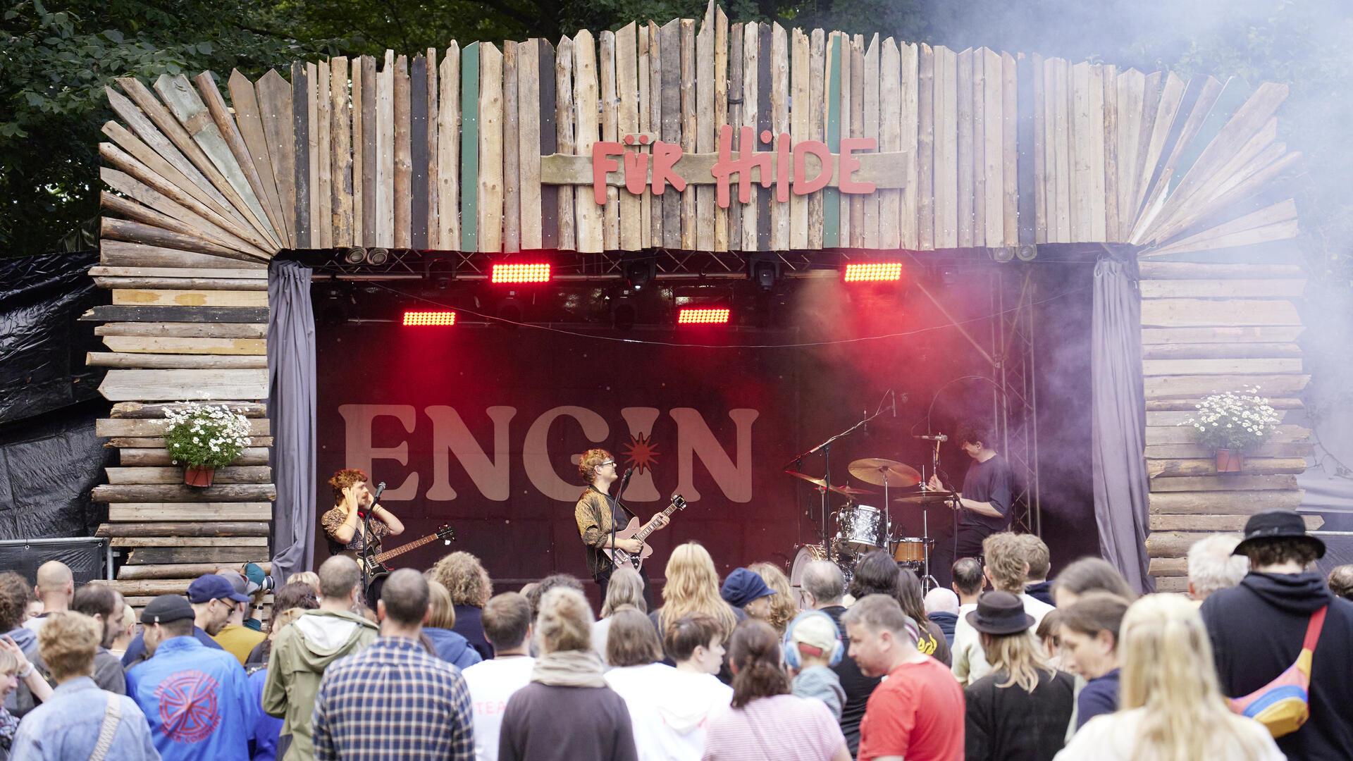 Eine Bühne mit Band und davor Publikum.