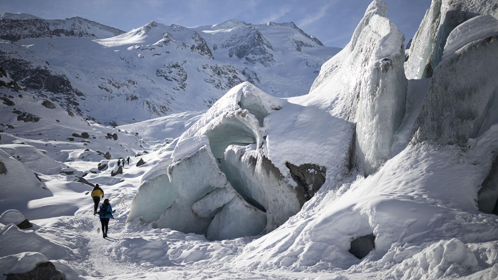 Bilder des Tages Sonne, Eis und Schnee: Während sich viele Menschen am Sonntag auf die faule Haut legen, werden diese Wanderer und sein Hund aktiv. Sie begehen den Morteratschgletscher in der Schweiz.