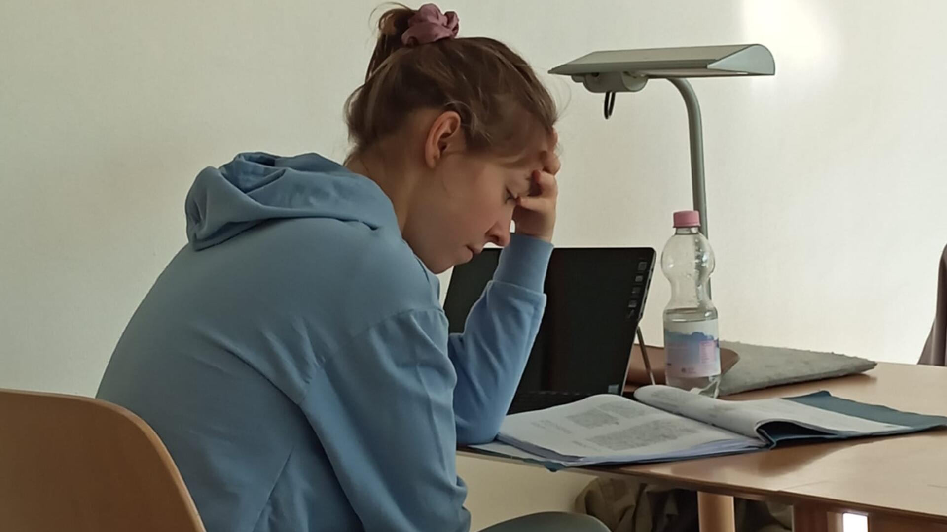 Frau liest an einem Schreibtisch. 