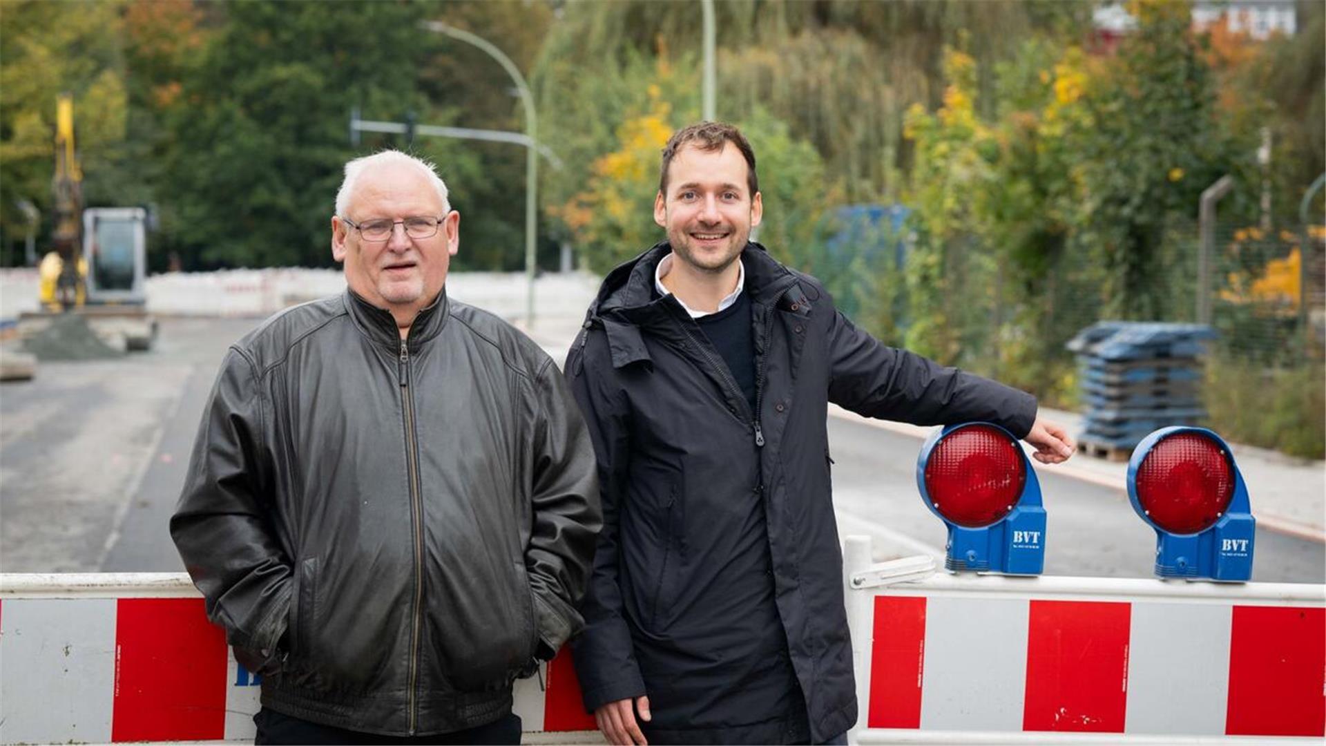Zwei Männer stehen auf einer Baustelle. 