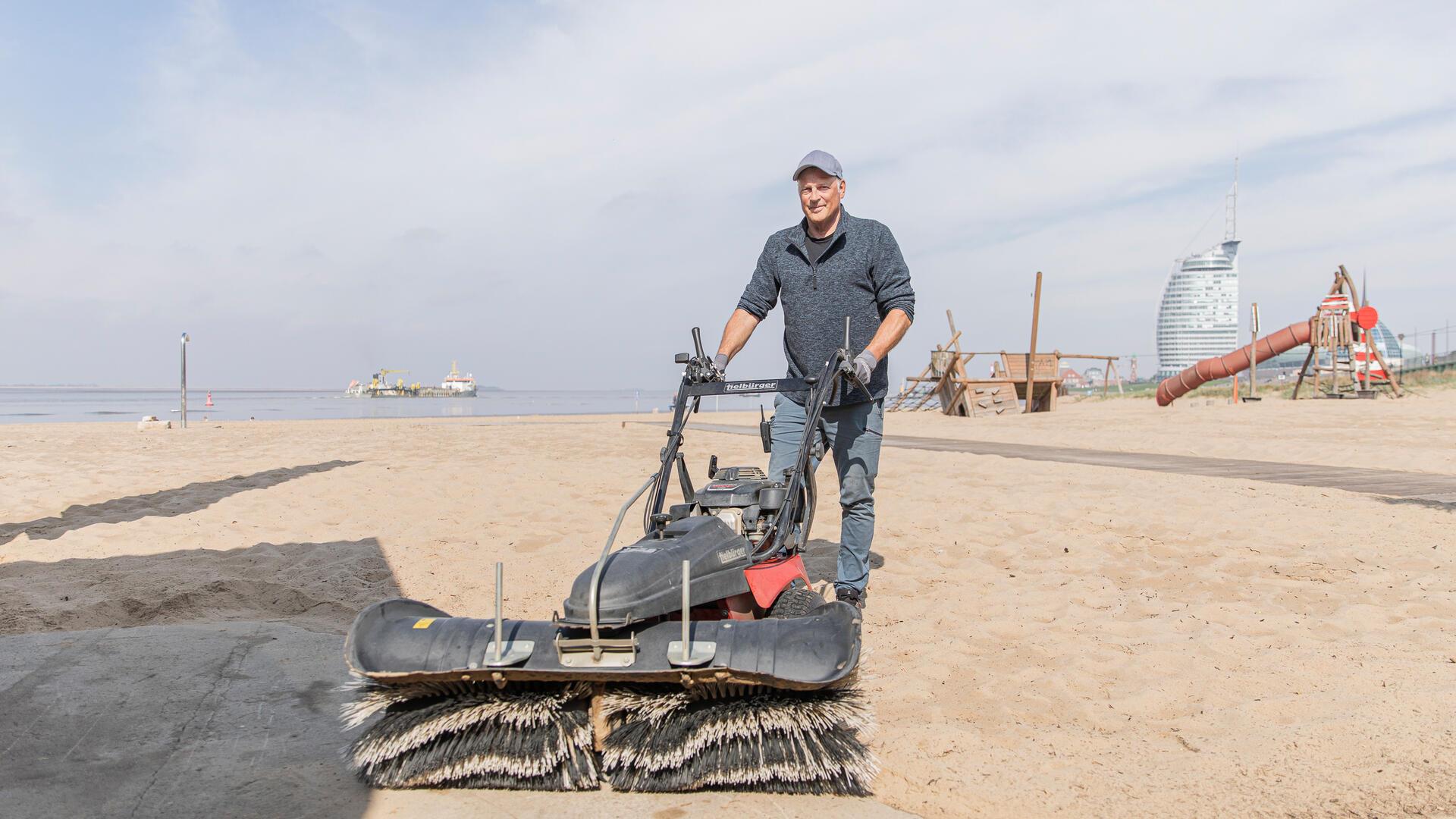 Mann mit Kehrmaschine: Strandmeister Olaf Ballhoff bringt den Sand und Wege auf Vordermann – für einen sauberen Saisonstart.