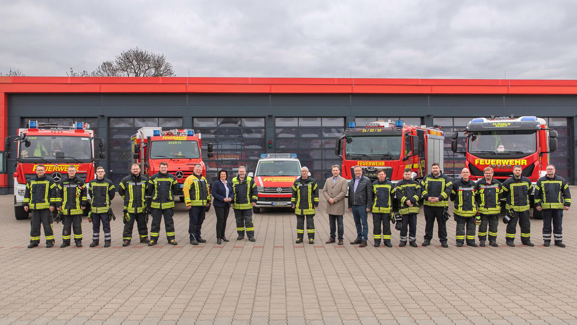 Feuerwehrkräfte und neue Fahrzeuge vor dem Feuerwehrhaus Langen