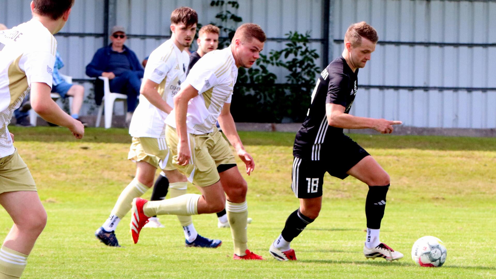 TSV-Ideengeber Fabian Lott (rechts) setzt sich locker gegen zwei Gegenspieler durch.
