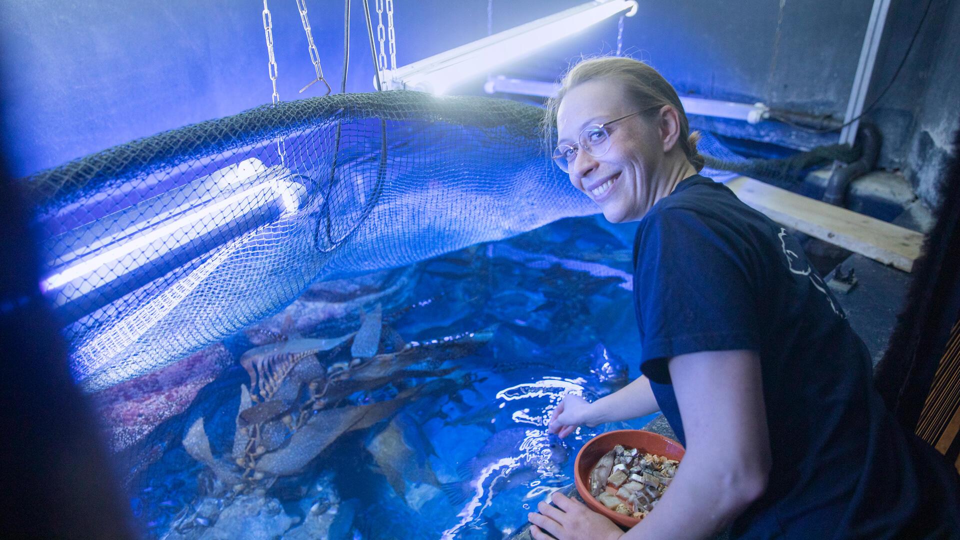Junge Frau vor einem Aquarium. Taissa Faust begrüßt als neue Leiterin die Besucher im Nordsee-Aquarium des Zoos am Meer.