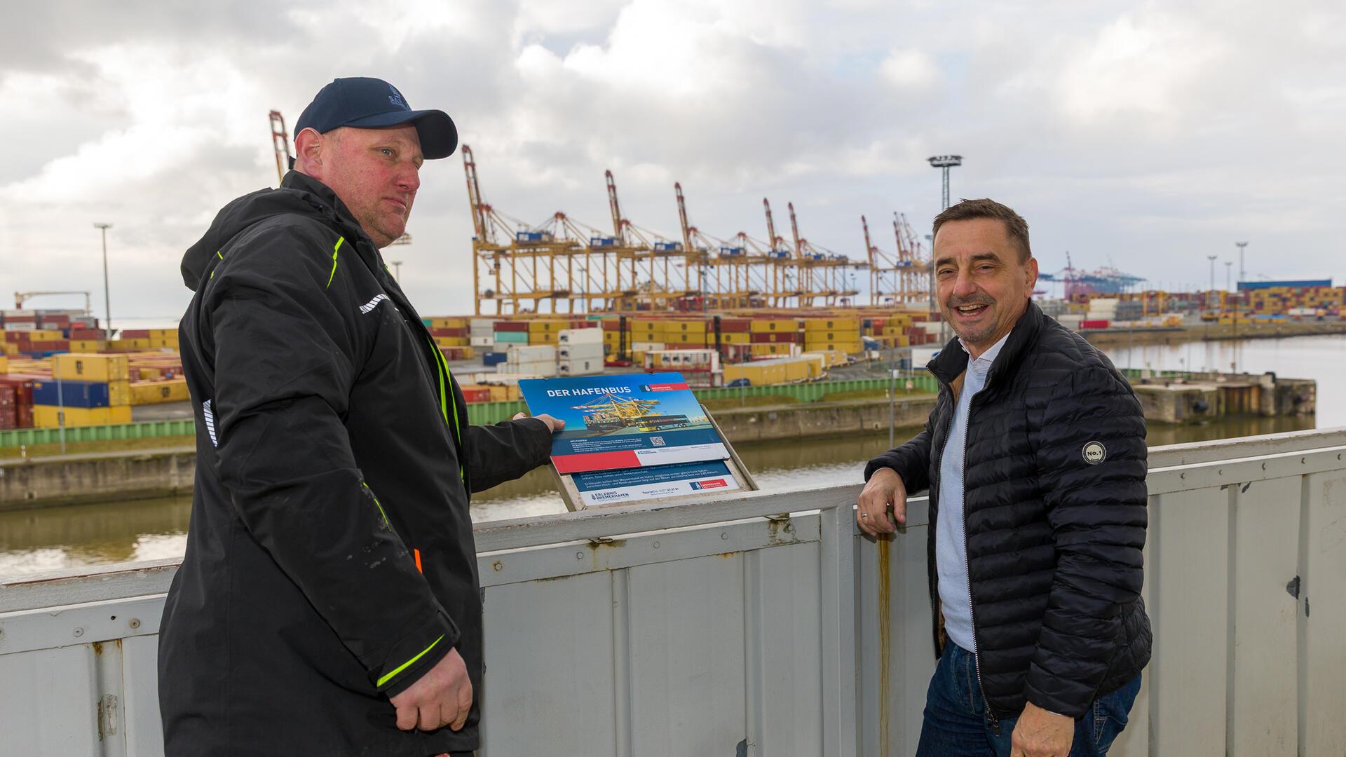 Sven Bade und Michael Gerber, der Geschäftsführer der Erlebnis Bremerhaven, haben die neuen Info-Tafeln auf dem Aussichtsturm angebracht.