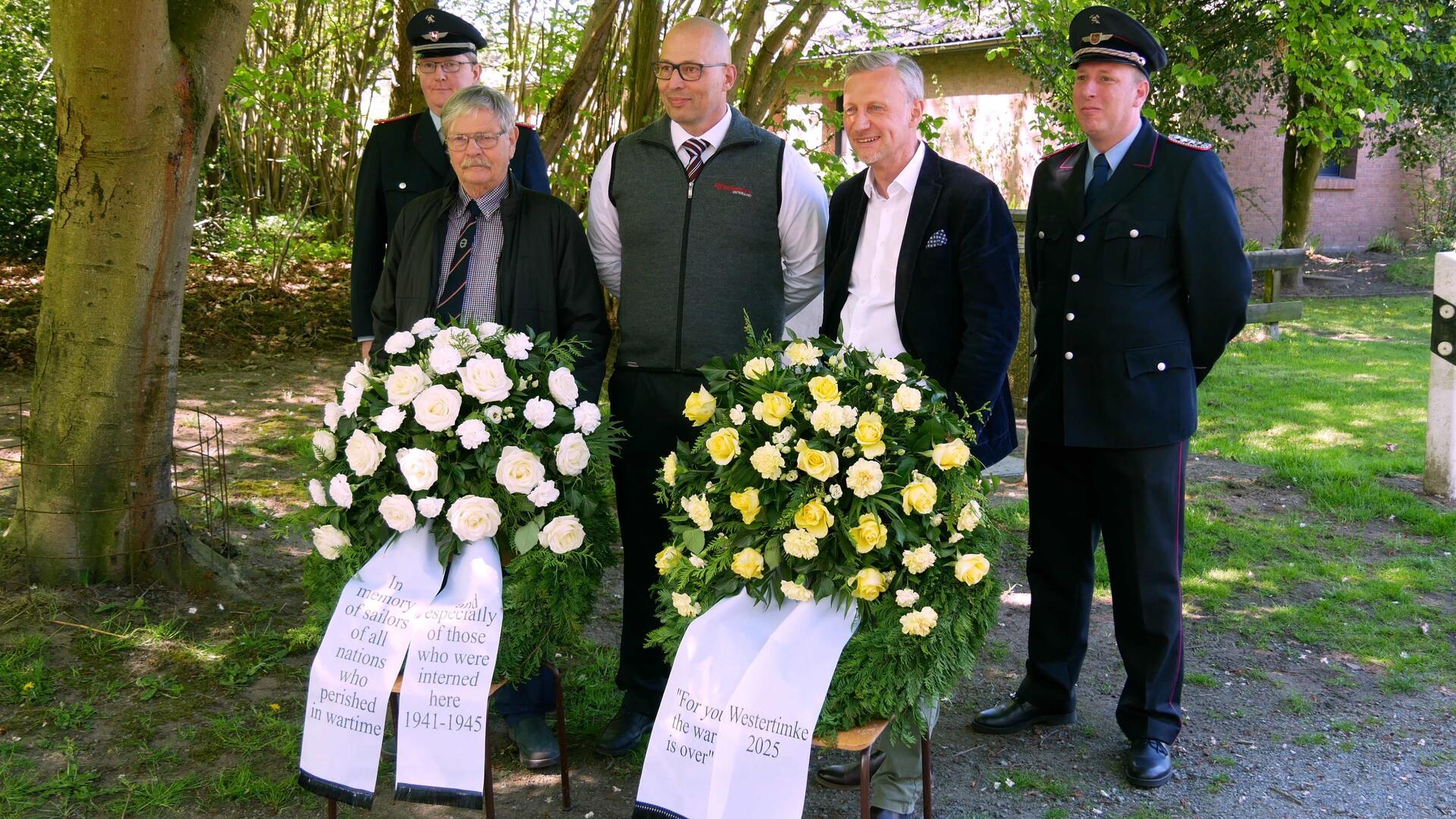 Thomas Gabe, Knut Ehlert und Michael Ahrens (von links) sowie die Gemeindebrandmeister gedachten der ehemaligen Kriegsgefangenen und legten Kränze an der Gedenktafel des Lagers MILAG nieder.