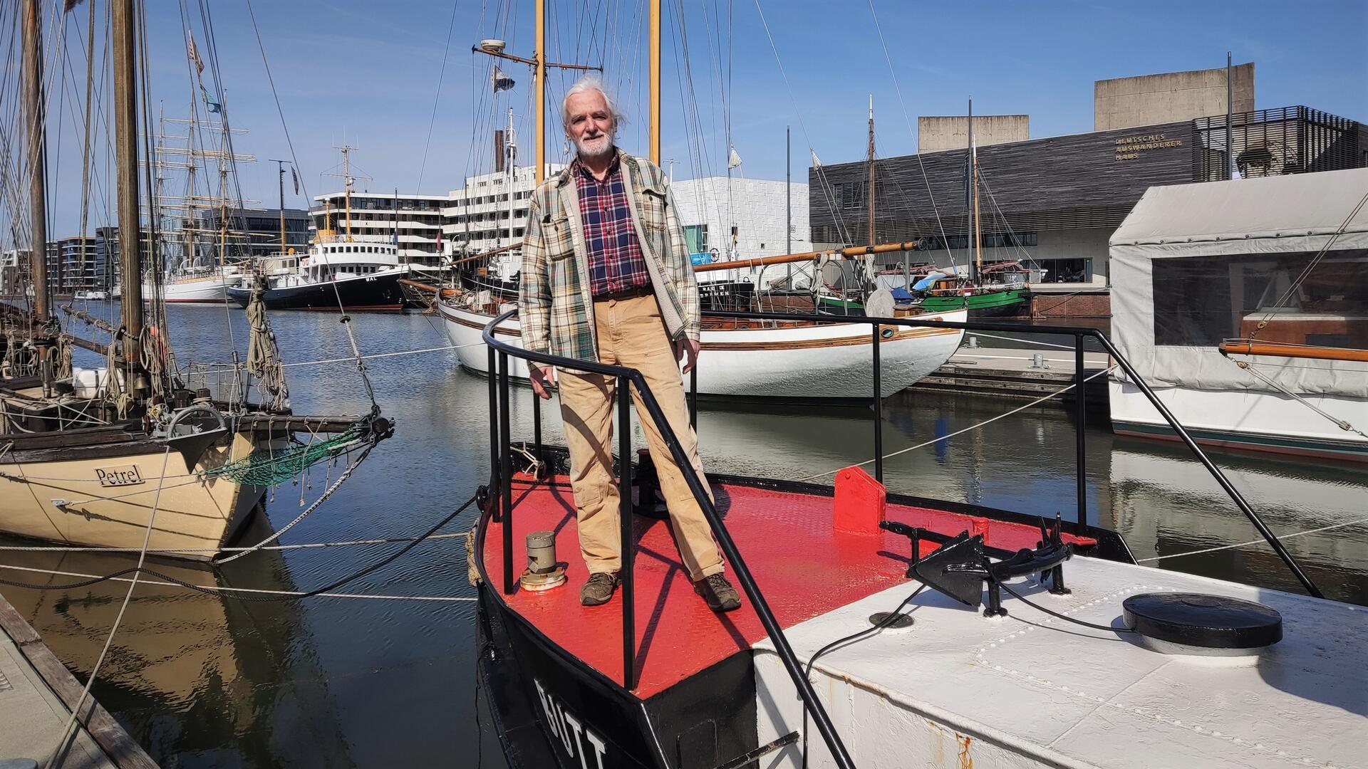 Thomas Herion steht auf seiner Hafenbarkasse in Bremerhaven.