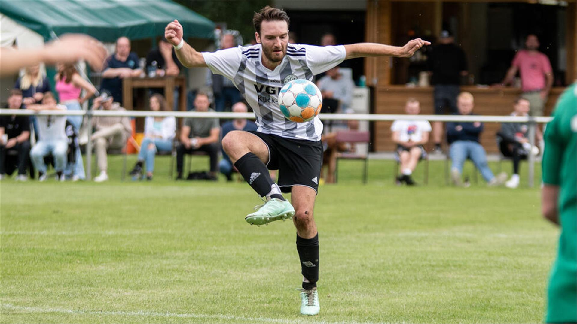 Ein Mann hat einen Ball auf dem Fuß.