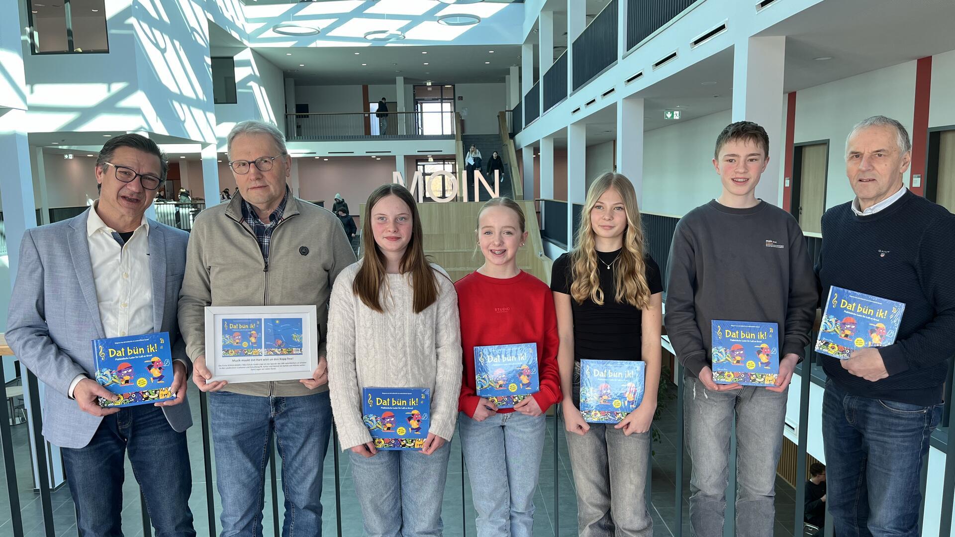 Übergabe der neuen plattdeutschen Gesangsbücher im Gymnasium Bremervörde: Direktor Dr. Uwe Strohbach (von links), Uwe Steffens, Natalia Seebeck, Greta Lange, Lilou Beckmann, Christian Leidig und Hans-Hinrich Kahrs.