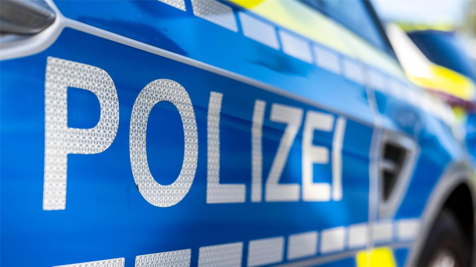 An der Tür von einem Streifenwagen steht der Schriftzug „Polizei“