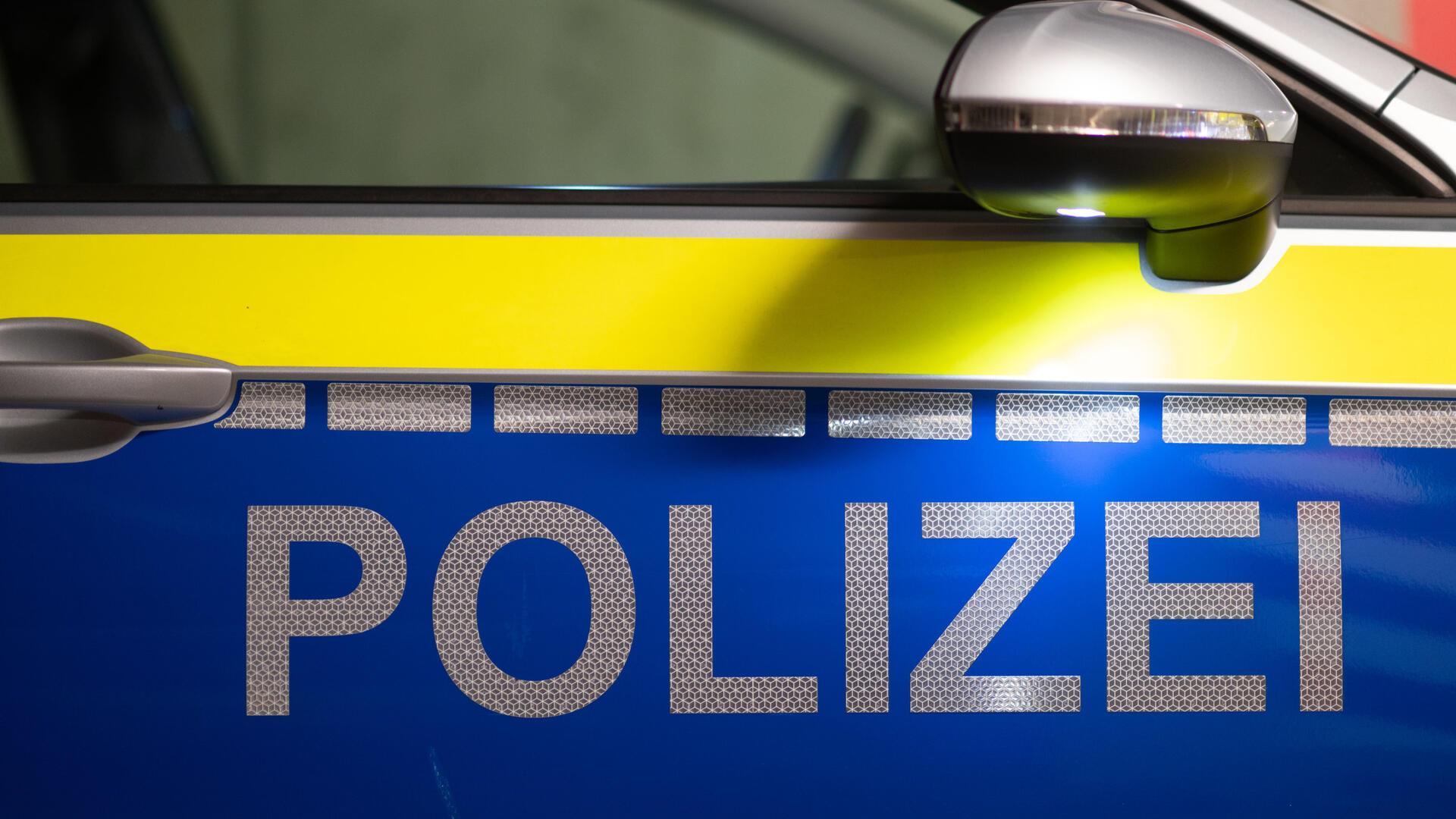 Das Wort Polizei ist auf der Tür eines Polizeiautos zu lesen.  
