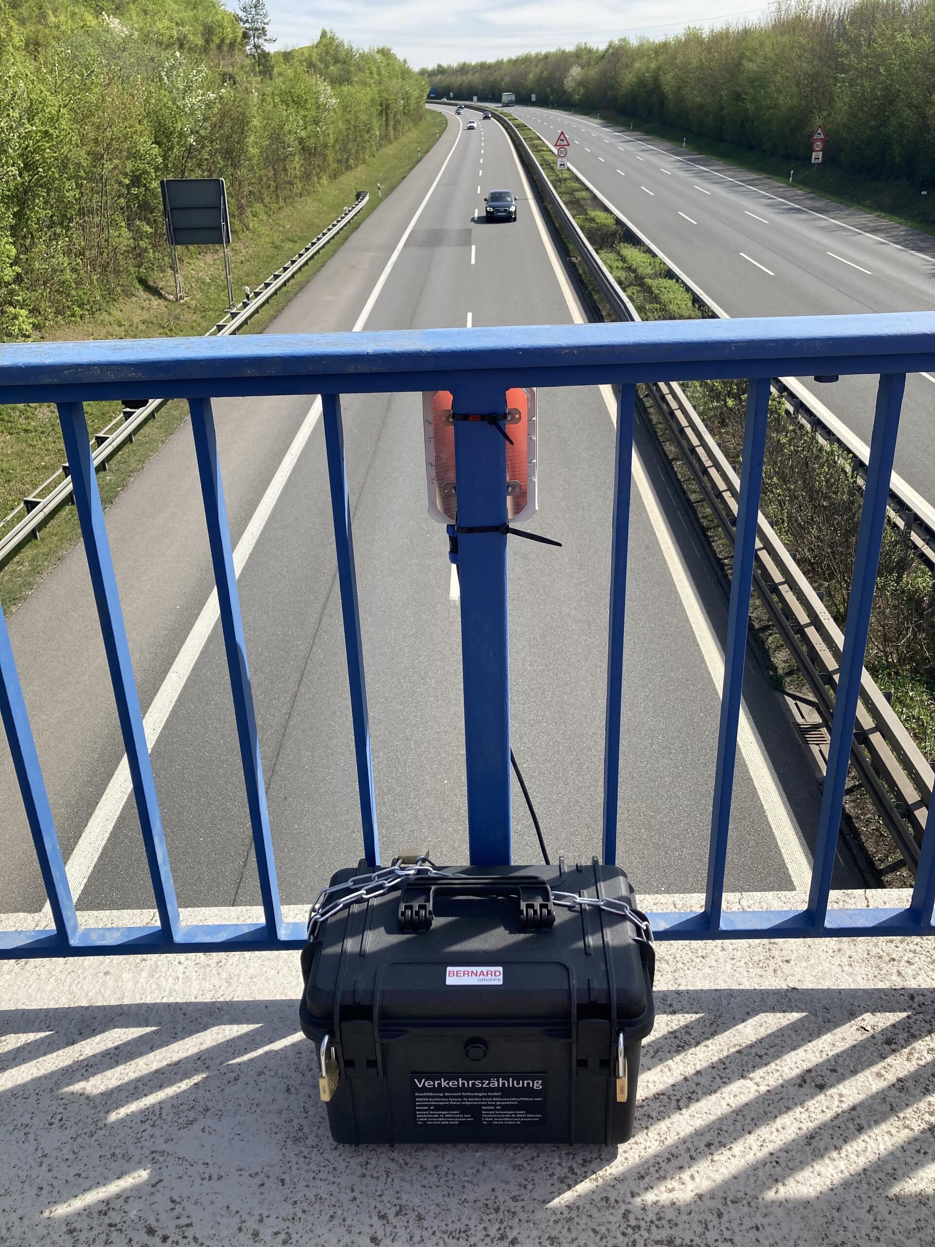 ein Gerät zur Verkehrszählung ist auf einer Brücke über einer Autobahn angebracht