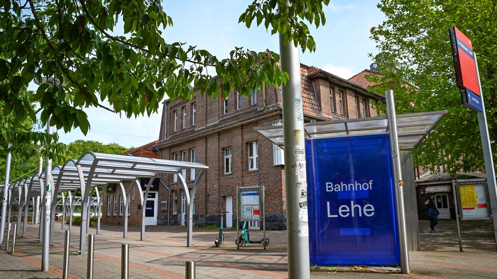 Vorplatz mit Bahnhofsgebäude und Schild „Bahnhof Lehe“.