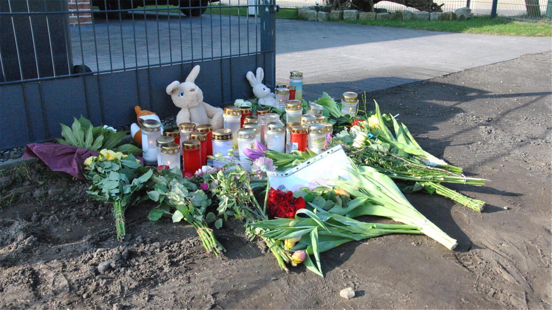 Blumen liegen vor dem Haus. 