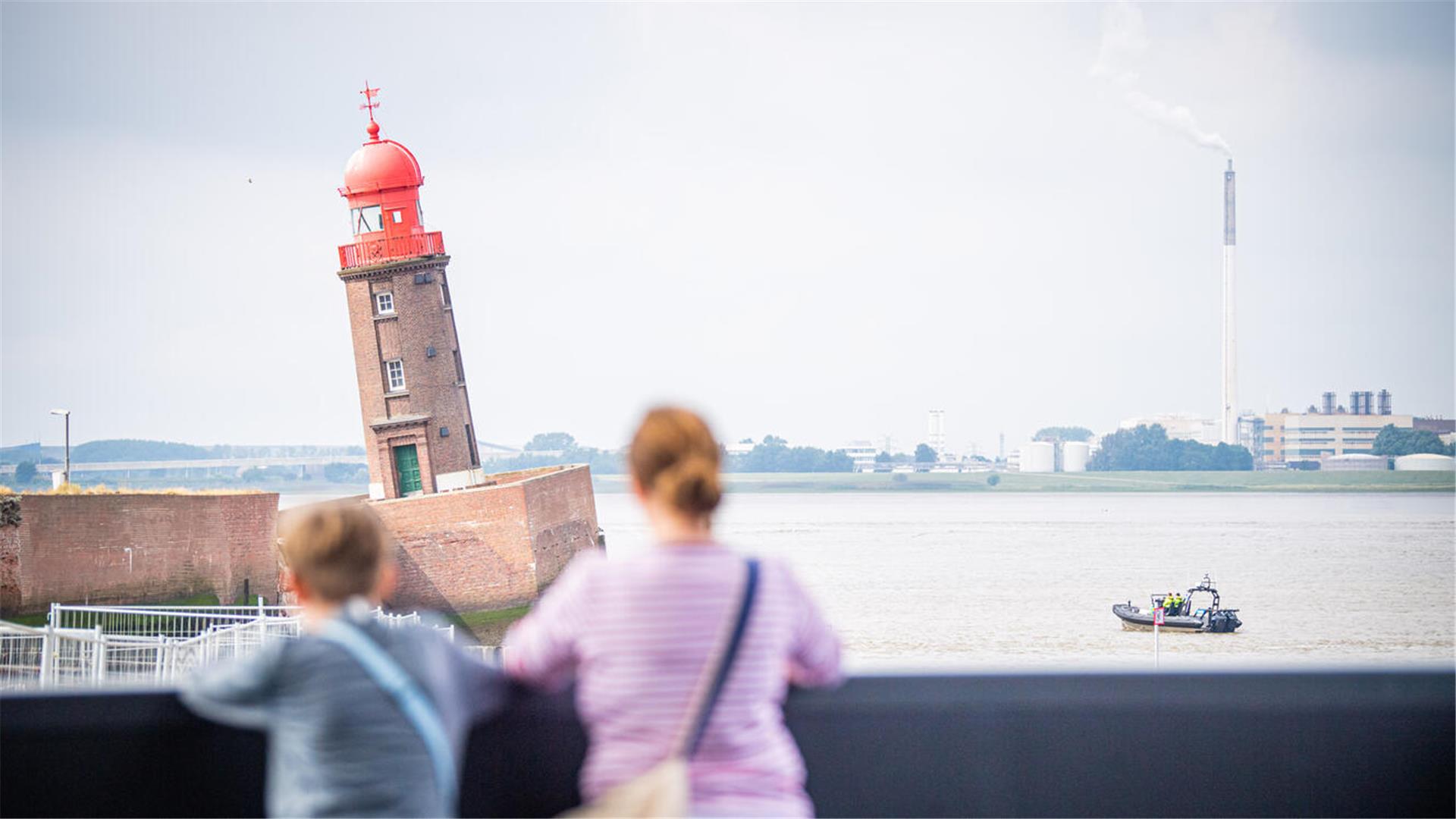 Zwei Menschen schauen auf den schiefen Turm.
