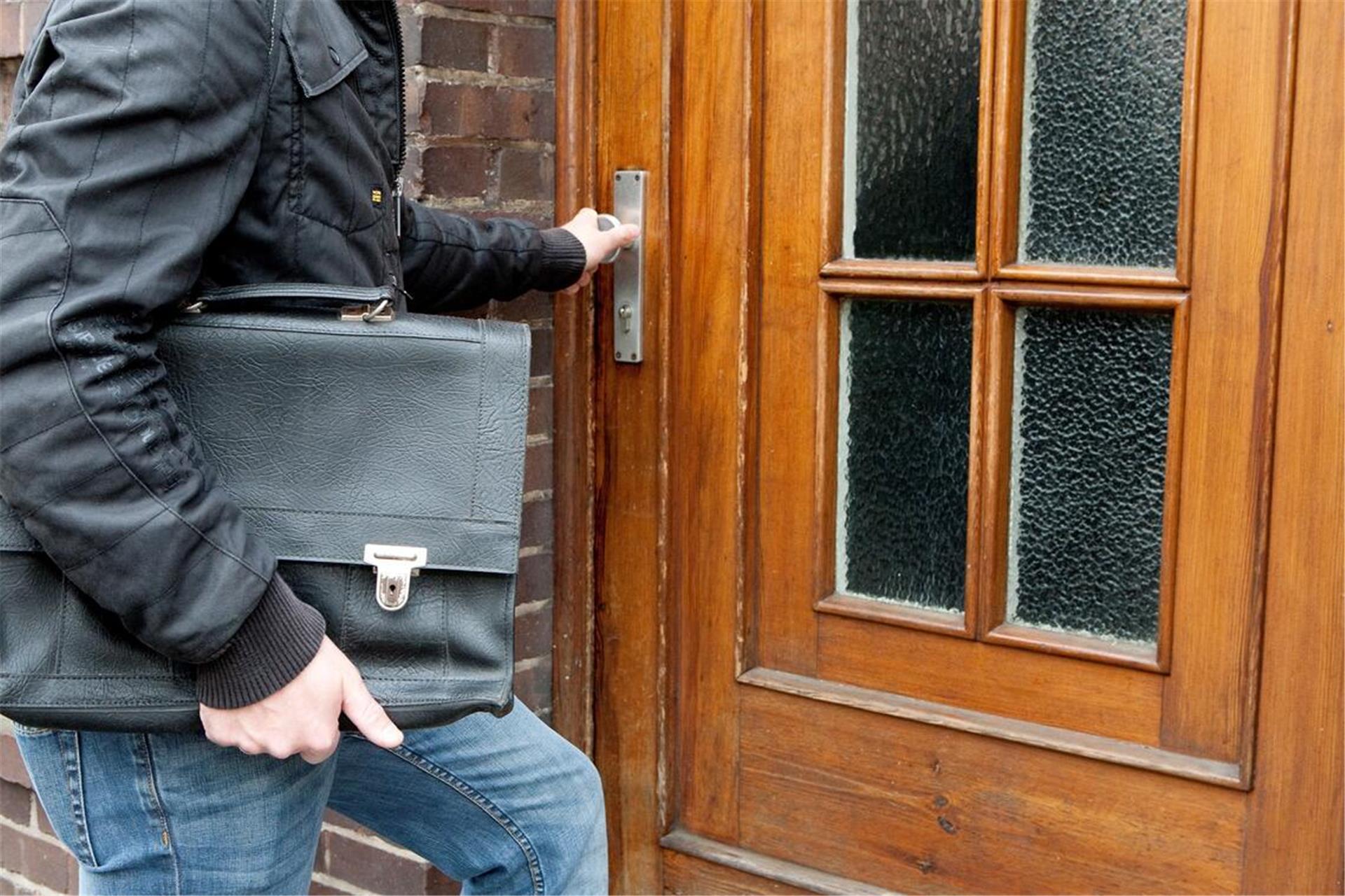 Mann mit Tasche an einer Tür