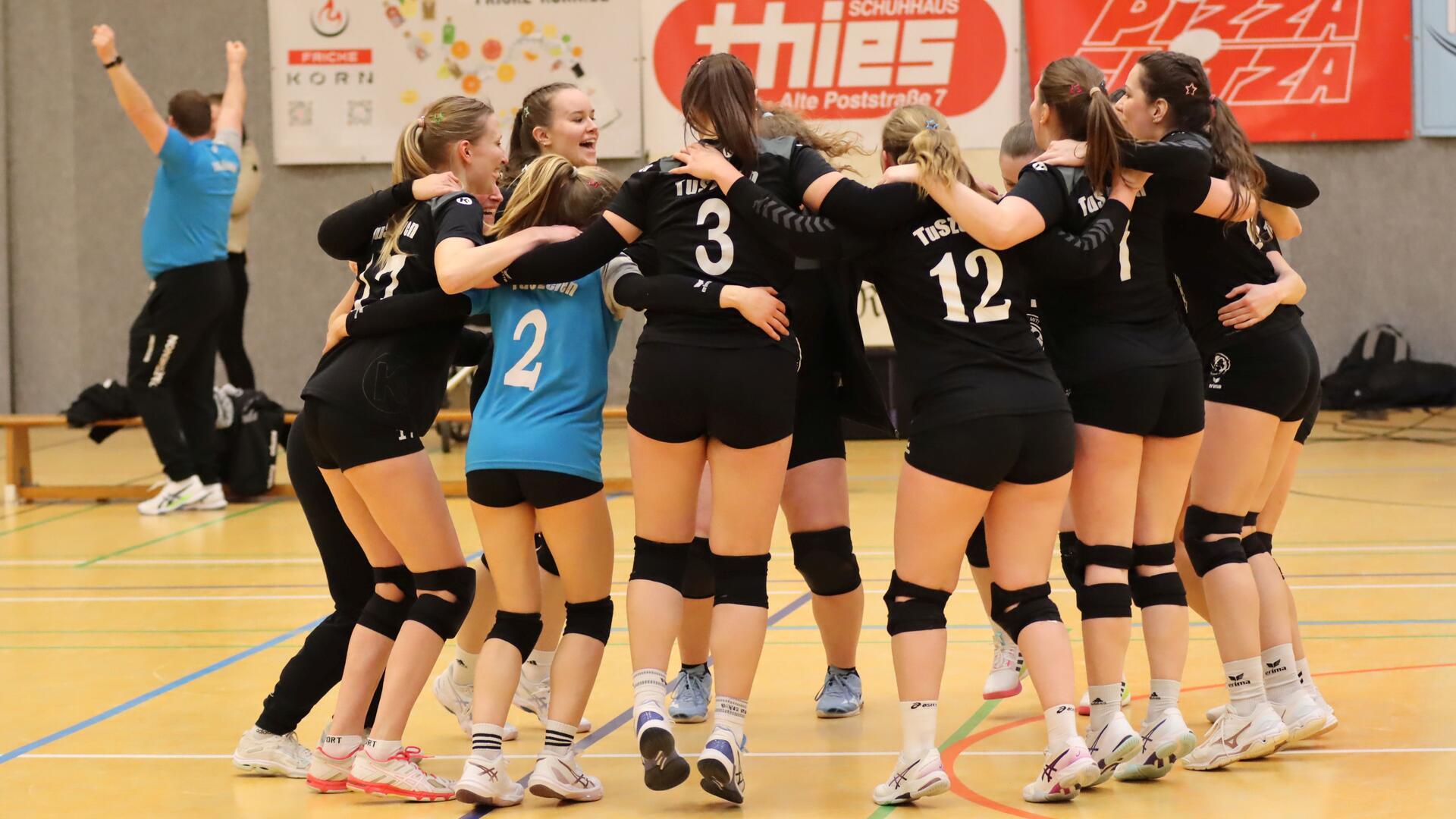 Während Trainer Axel Körner im Hintergrund die geballten Fäuste in die Höhe reckt, feiern seine Spielerinnen ausgelassen den Doppelsieg und den Klassenerhalt in der Volleyball-Oberliga.