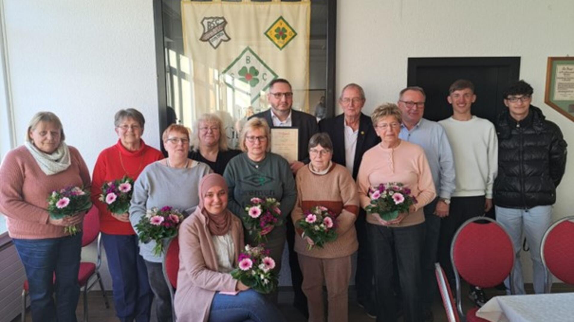 Männer und Frauen stehen in einer Gruppe zusammen.
