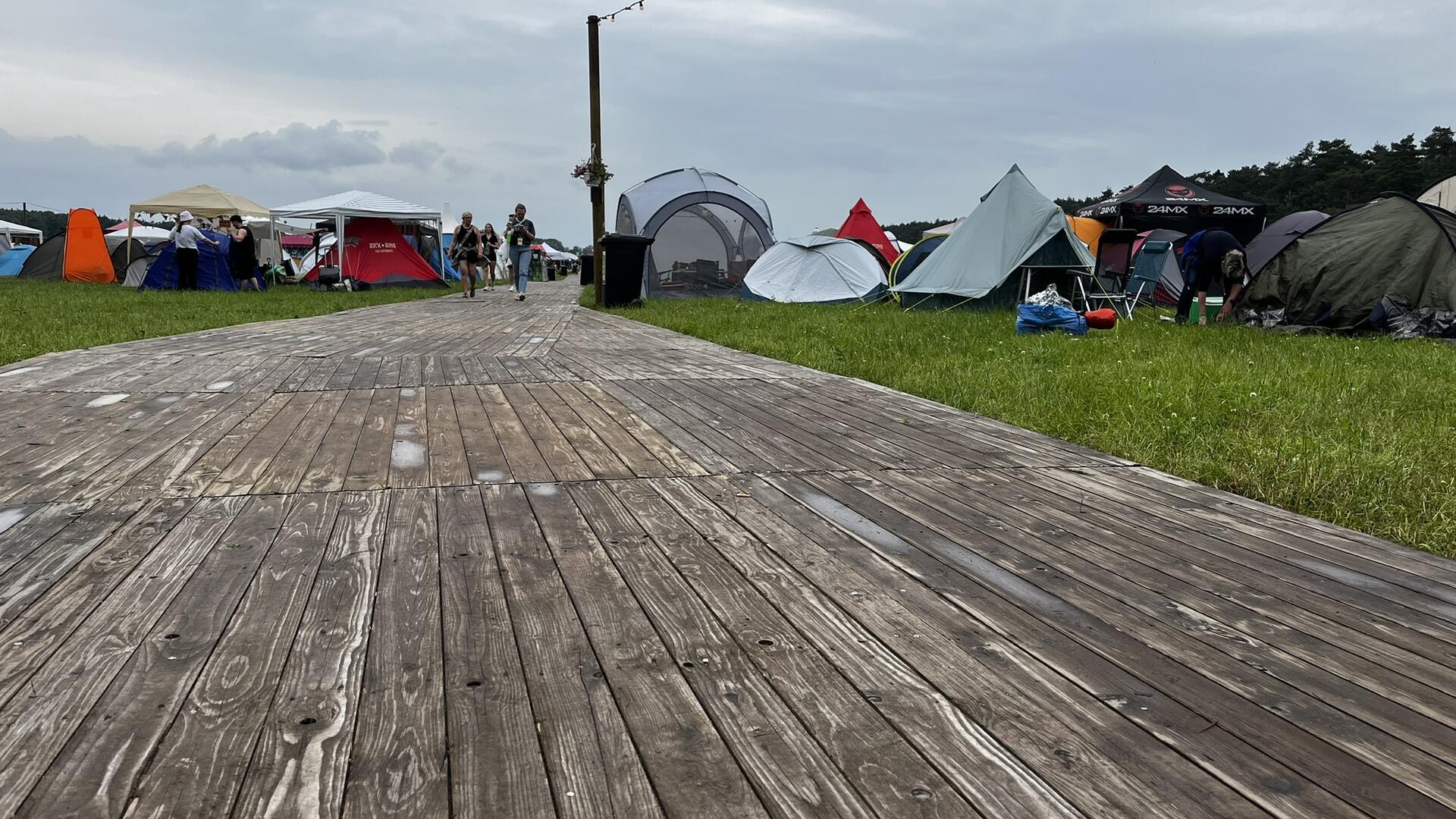Zelt-Rivalen: Glamping-Luxus gegen Camping-Romantik beim Hurricane Festival Ein Holzweg auf einem Zeltplatz.